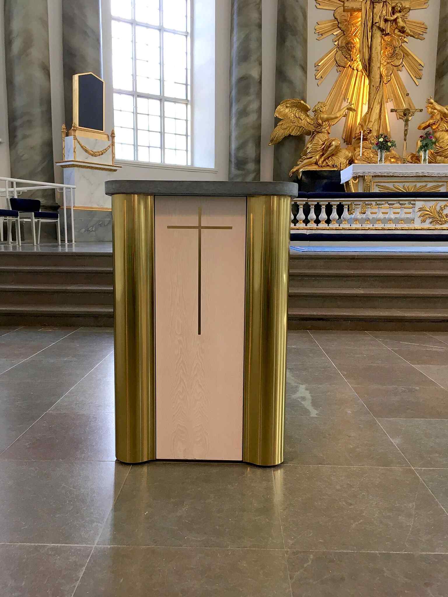 This baptismal font reflects the intricate carvings and historical images characteristic of pieces crafted by sculptor Marcus Jaeger the Elder in the late 17th century.