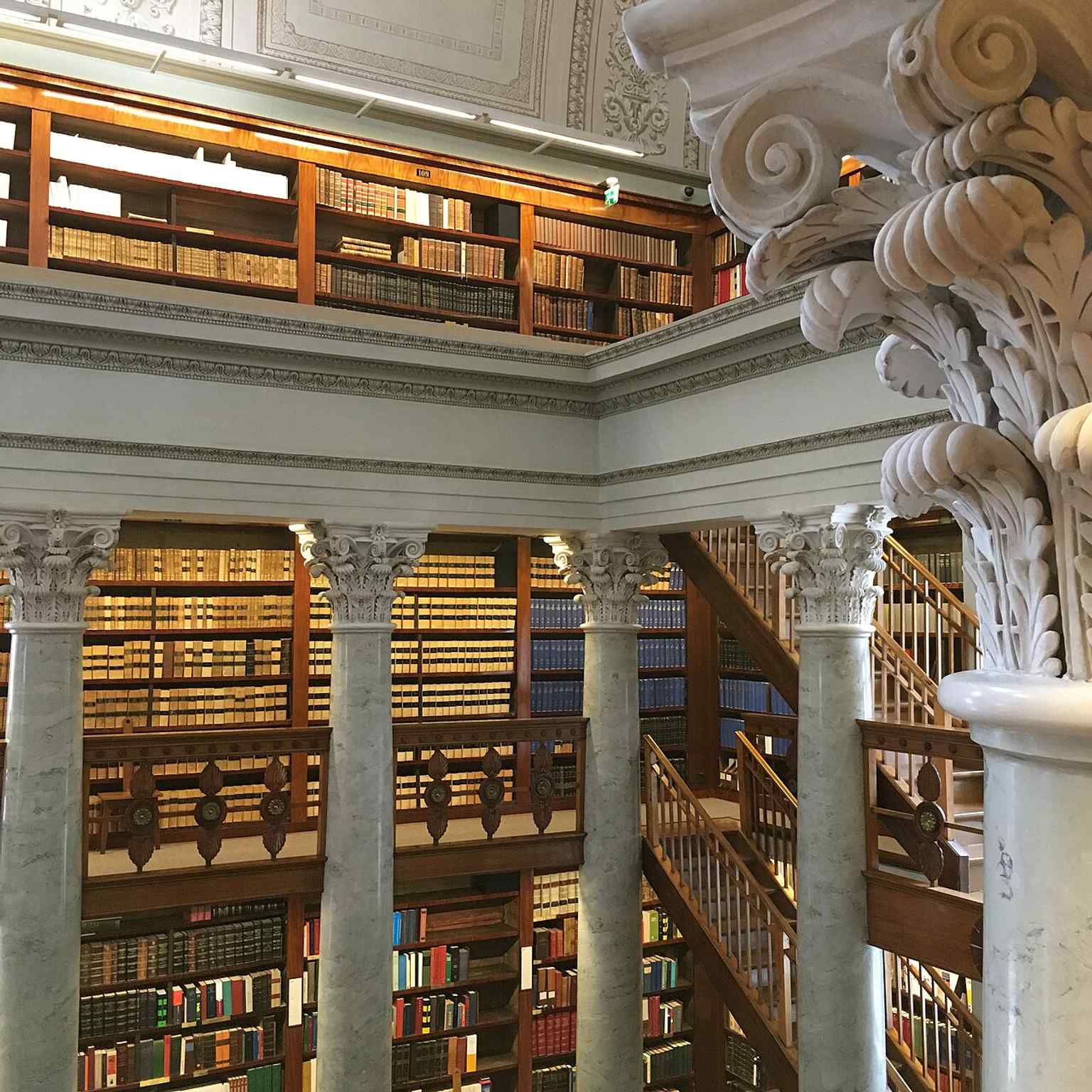 Rows of books and columns inside the library, echoing the institution’s vast collections and monumental interior design.