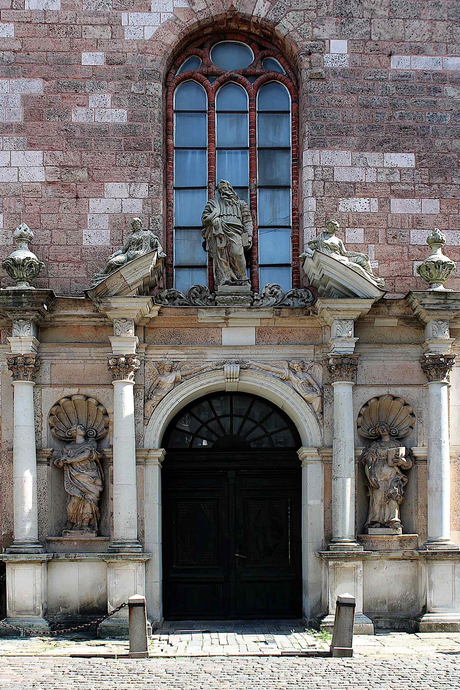 The church’s door detail adds a human-scale view of the building’s exterior, contrasting with the soaring tower above.