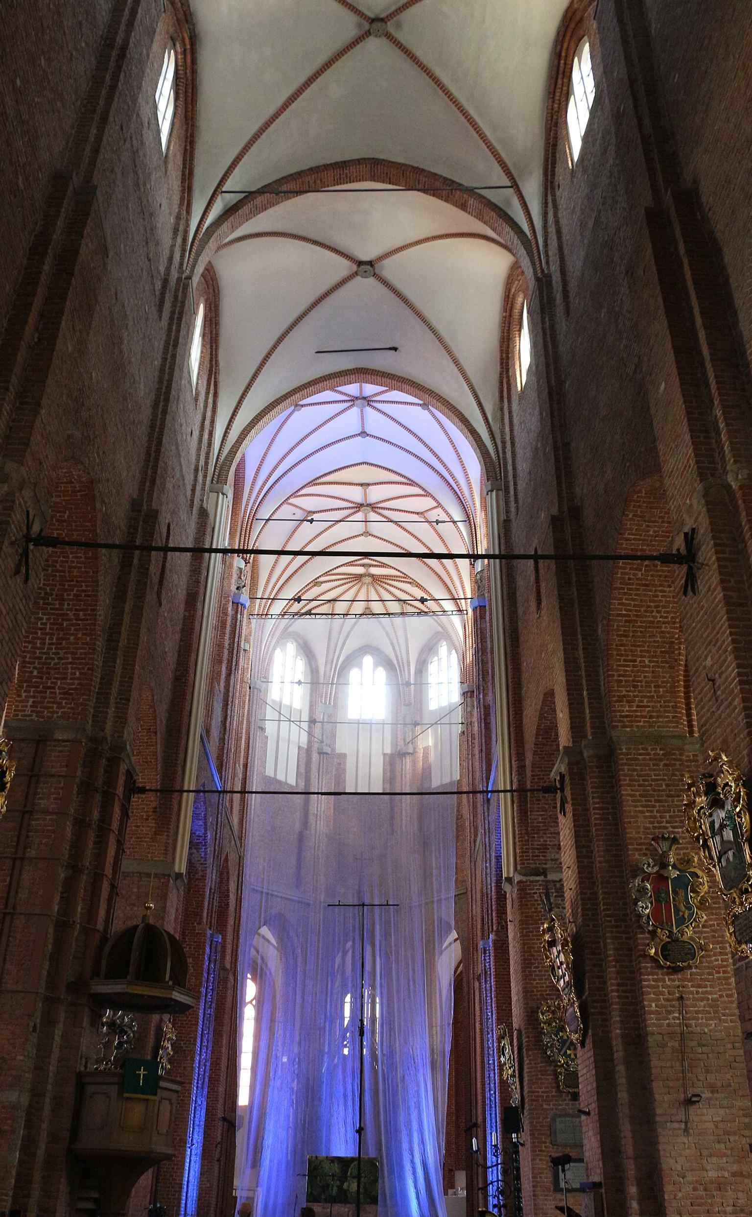 The church interior shows the restored worship space inside the medieval shell, where old stone structure meets later rebuilding.