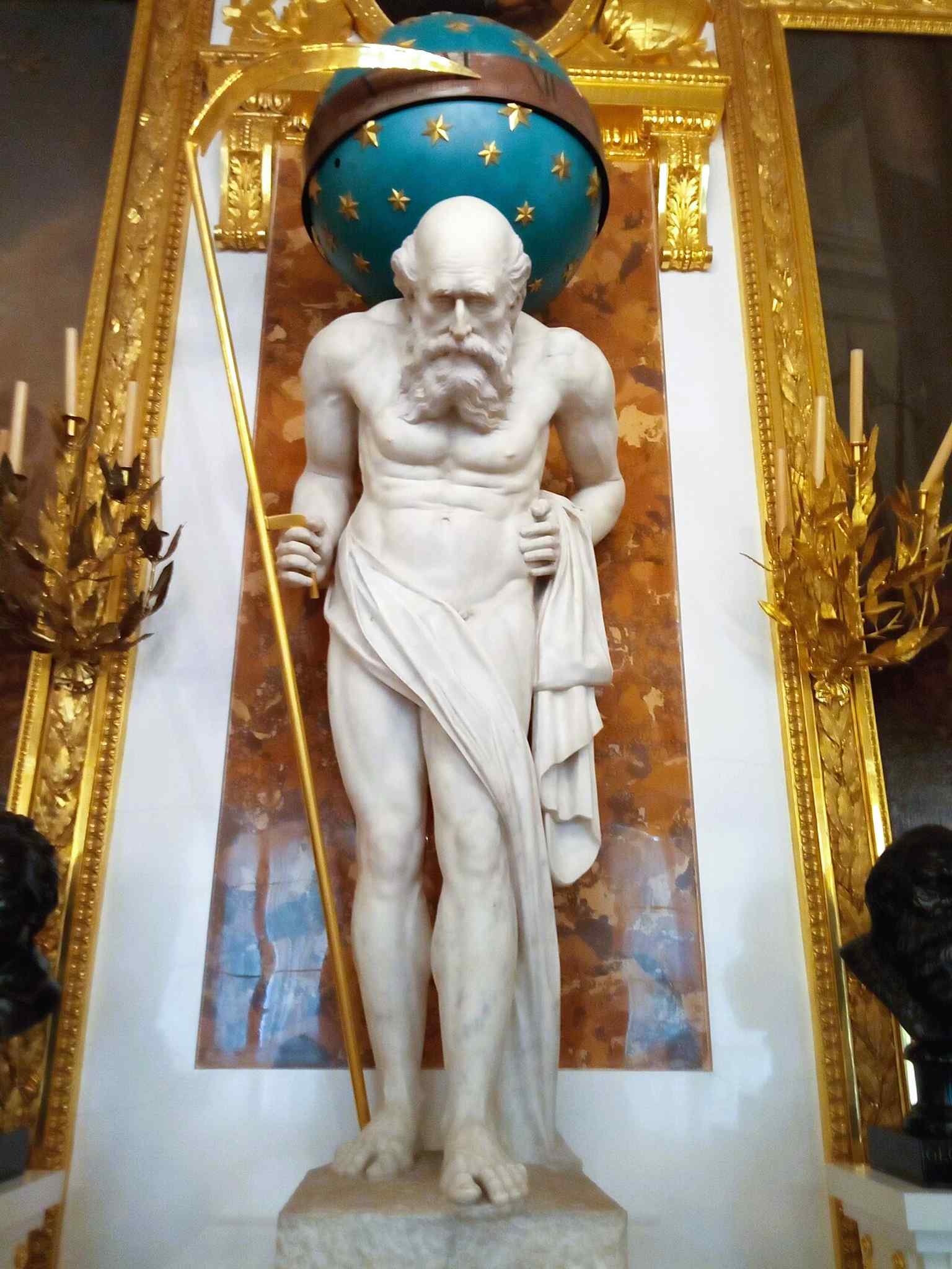 The sculpture of Chronos in the interior highlights the castle’s museum character and the dramatic symbolism embedded in its décor.