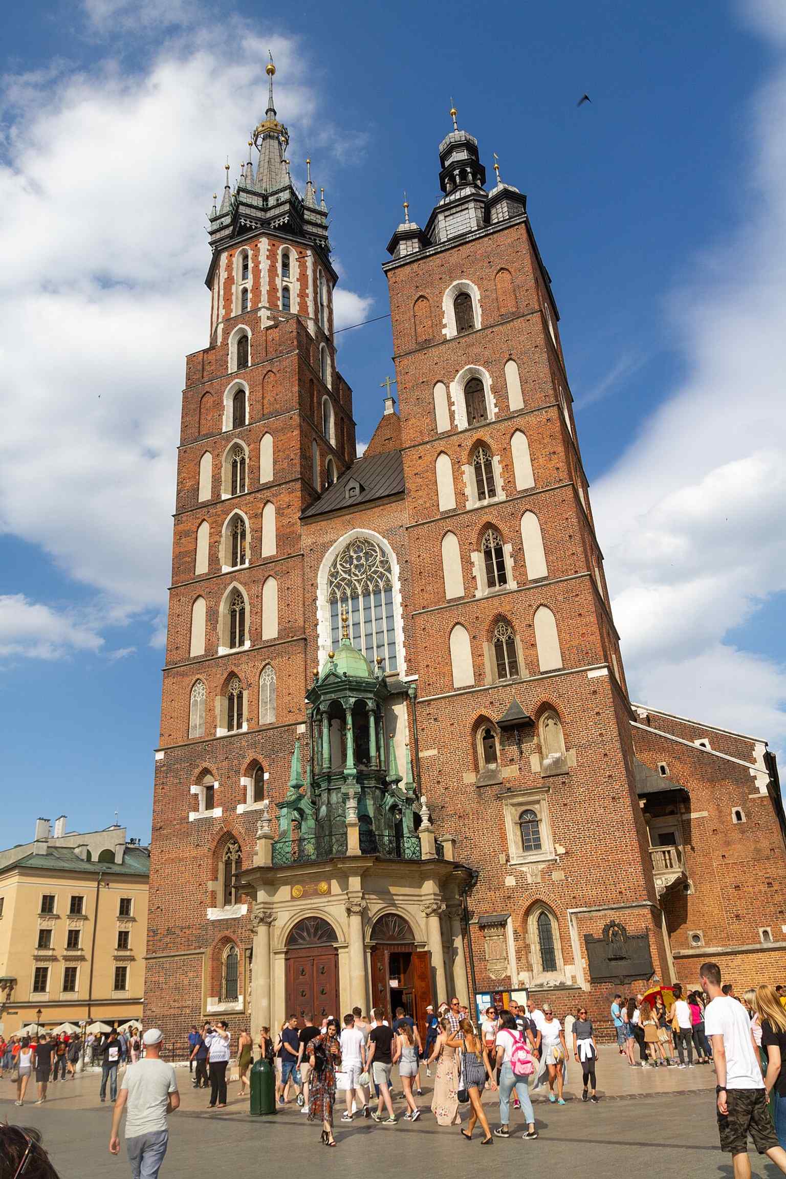 The basilica’s exterior in a clear contemporary view, highlighting the famous asymmetry of the two towers and the church’s role on the corner of the Main Square.