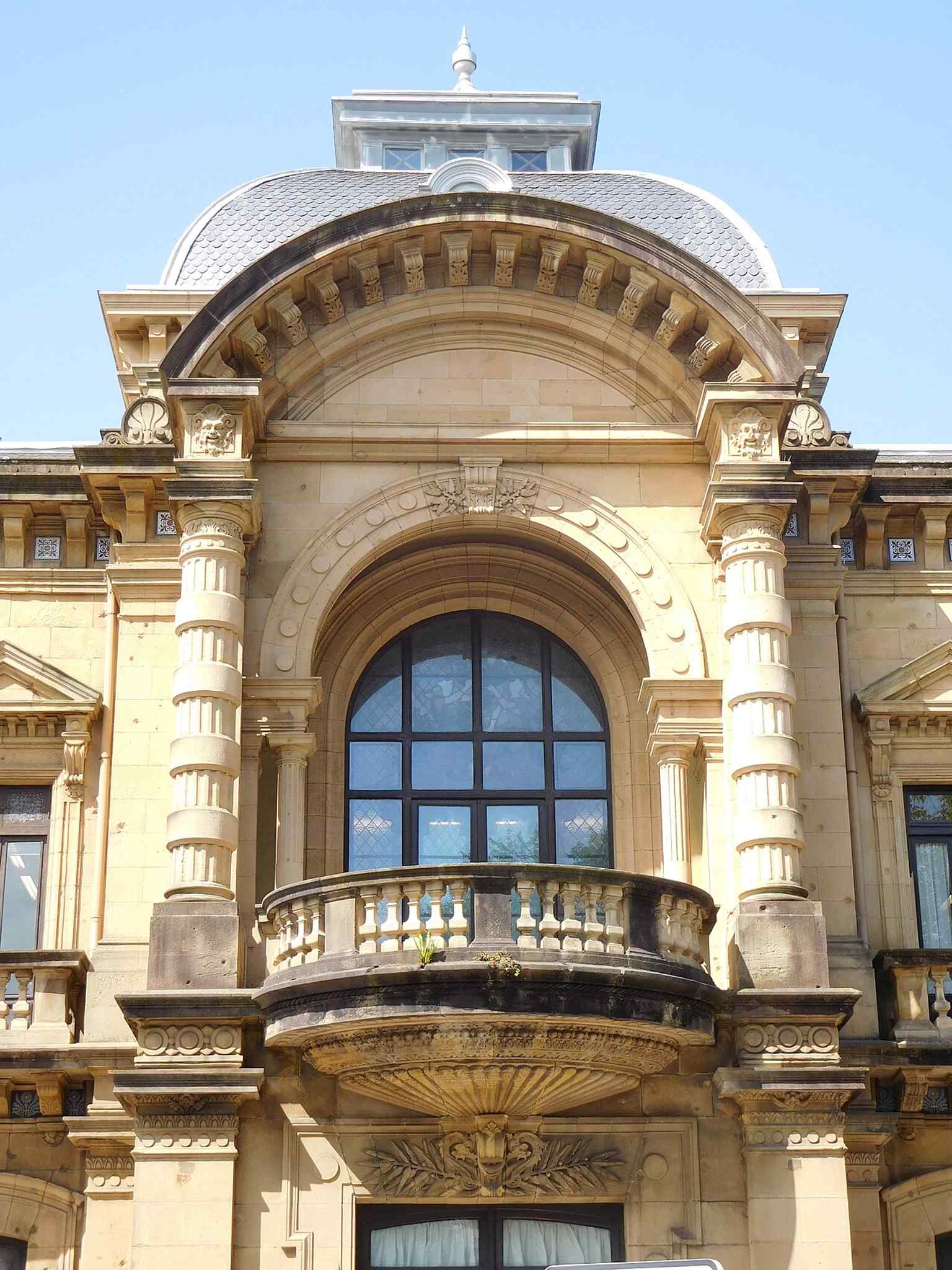The clock and coat of arms detail on the facade, a close look at the civic identity of the building.