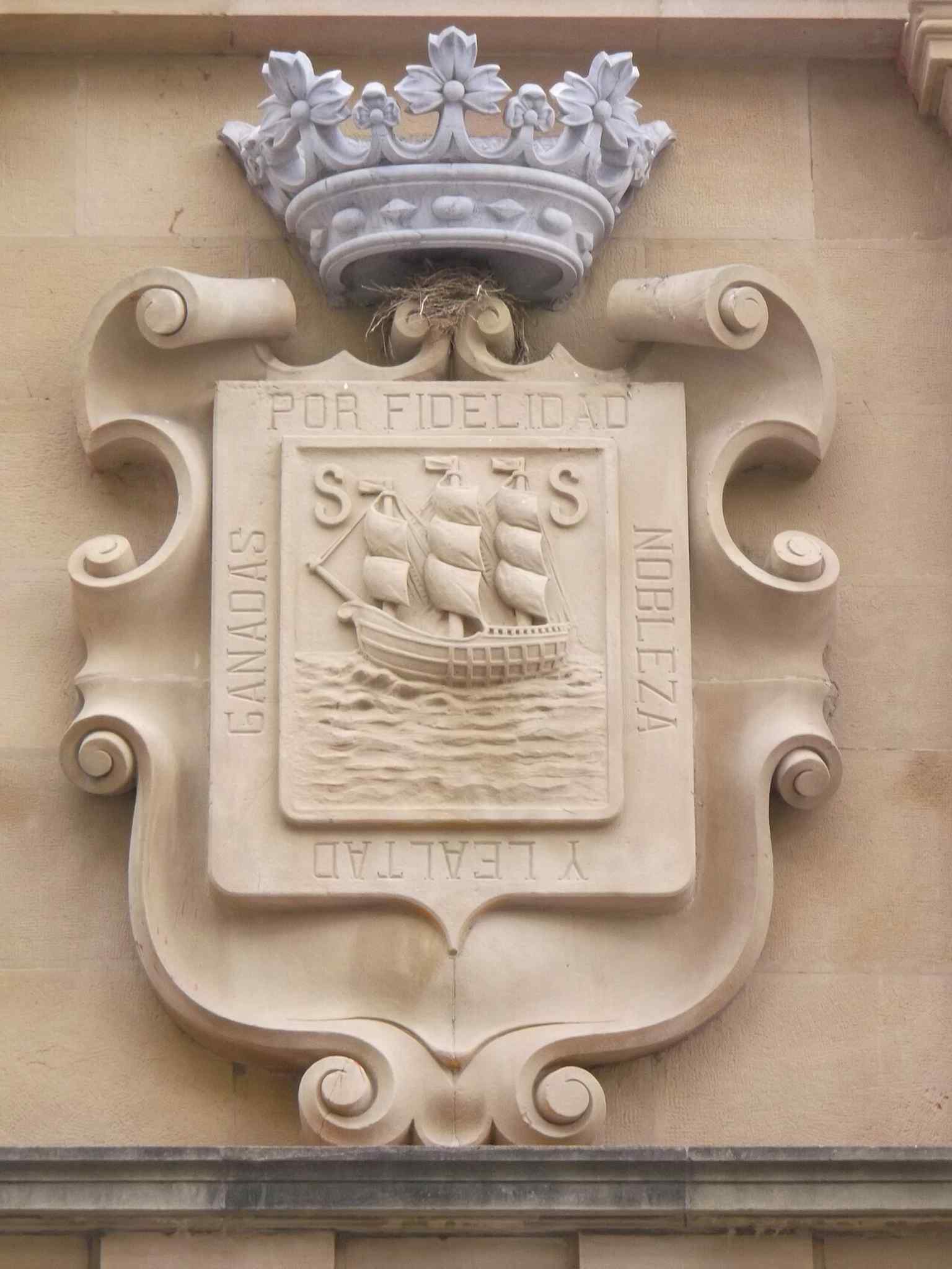 The city’s coat of arms on the old casino building, linking the grand 19th-century structure to civic power.