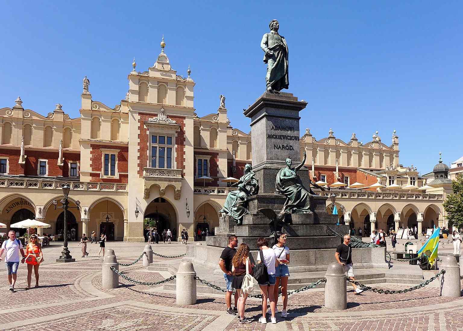 The monument with the Cloth Hall behind it, exactly where the statue became a central symbol of the Main Market Square.