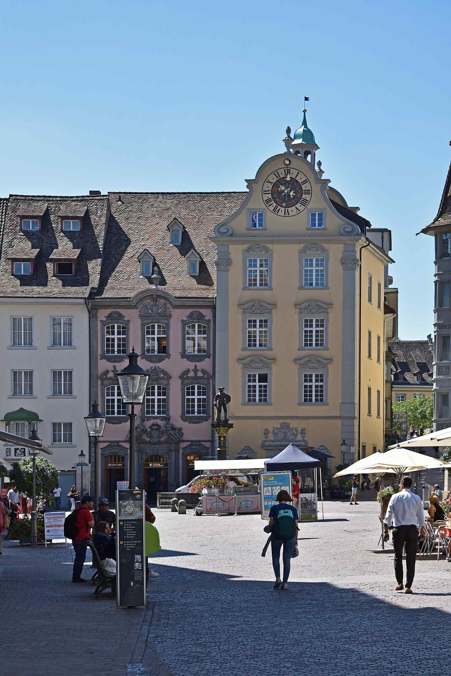 A classic view of the square’s south side: Zunfthaus Herrenstube beside the Fronwagturm, the landmark tower with its historic astronomical clock.