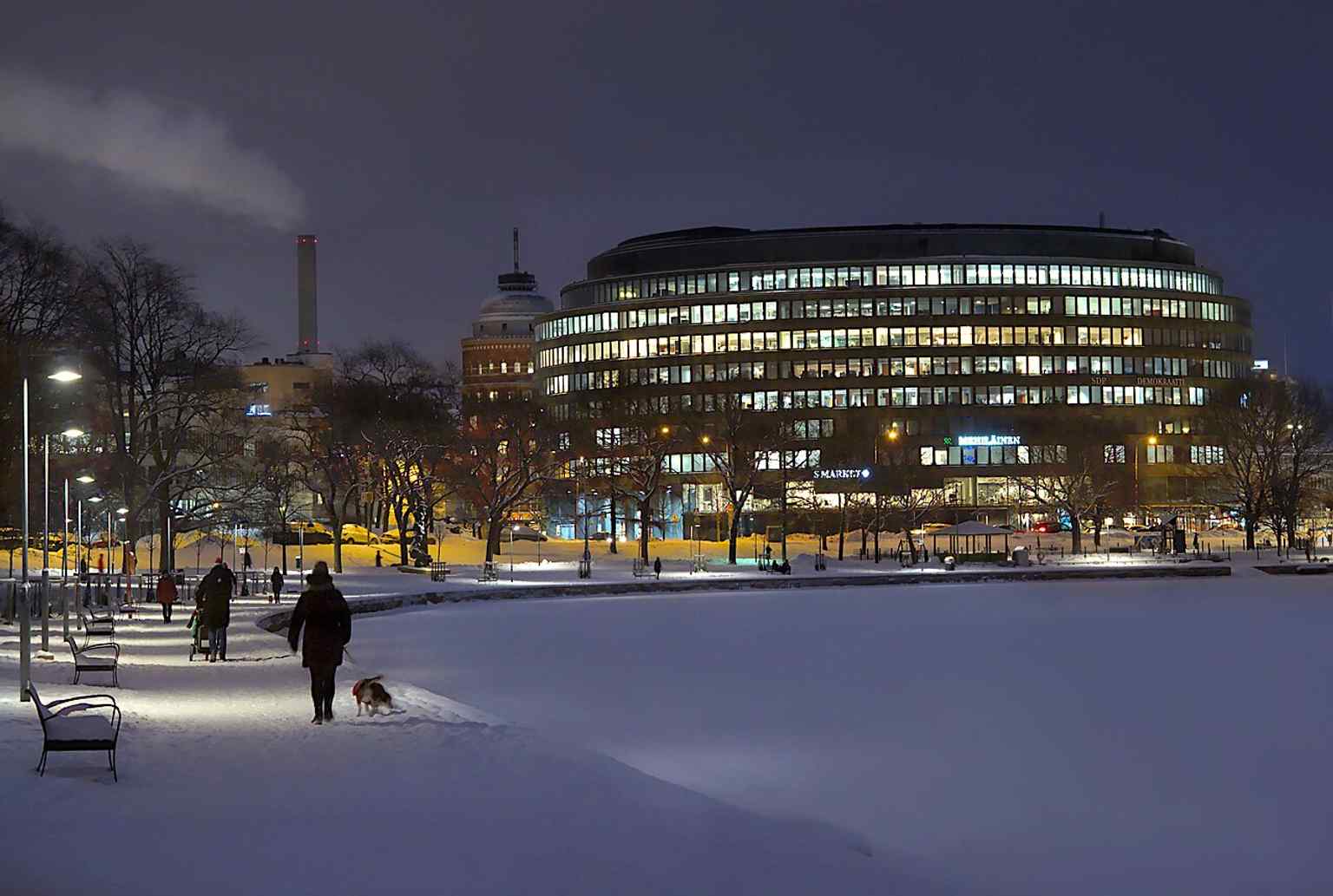 Ympyrätalo in winter, a clear exterior view of the 1968 former bank building that now houses shops and services.