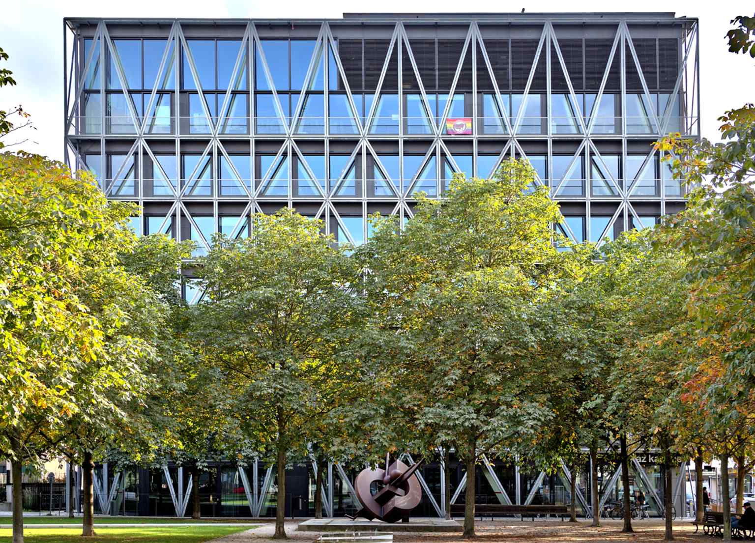 The taz publishing building seen from Besselpark, with public art in front of it — a contemporary view of the paper’s Berlin headquarters.