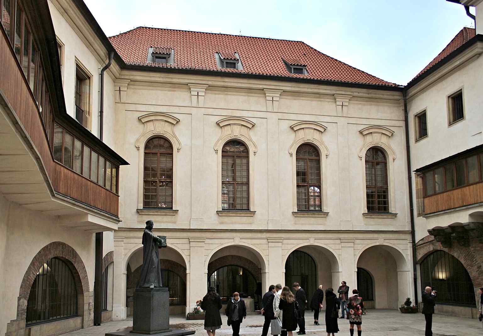 Die bewegende Szene von Jan Palachs Sarg, der 1969 im Karolinum aufgebahrt wurde, platziert neben der Statue von Meister Jan Hus, was einen gemeinsamen Geist des Widerstands widerspiegelt.