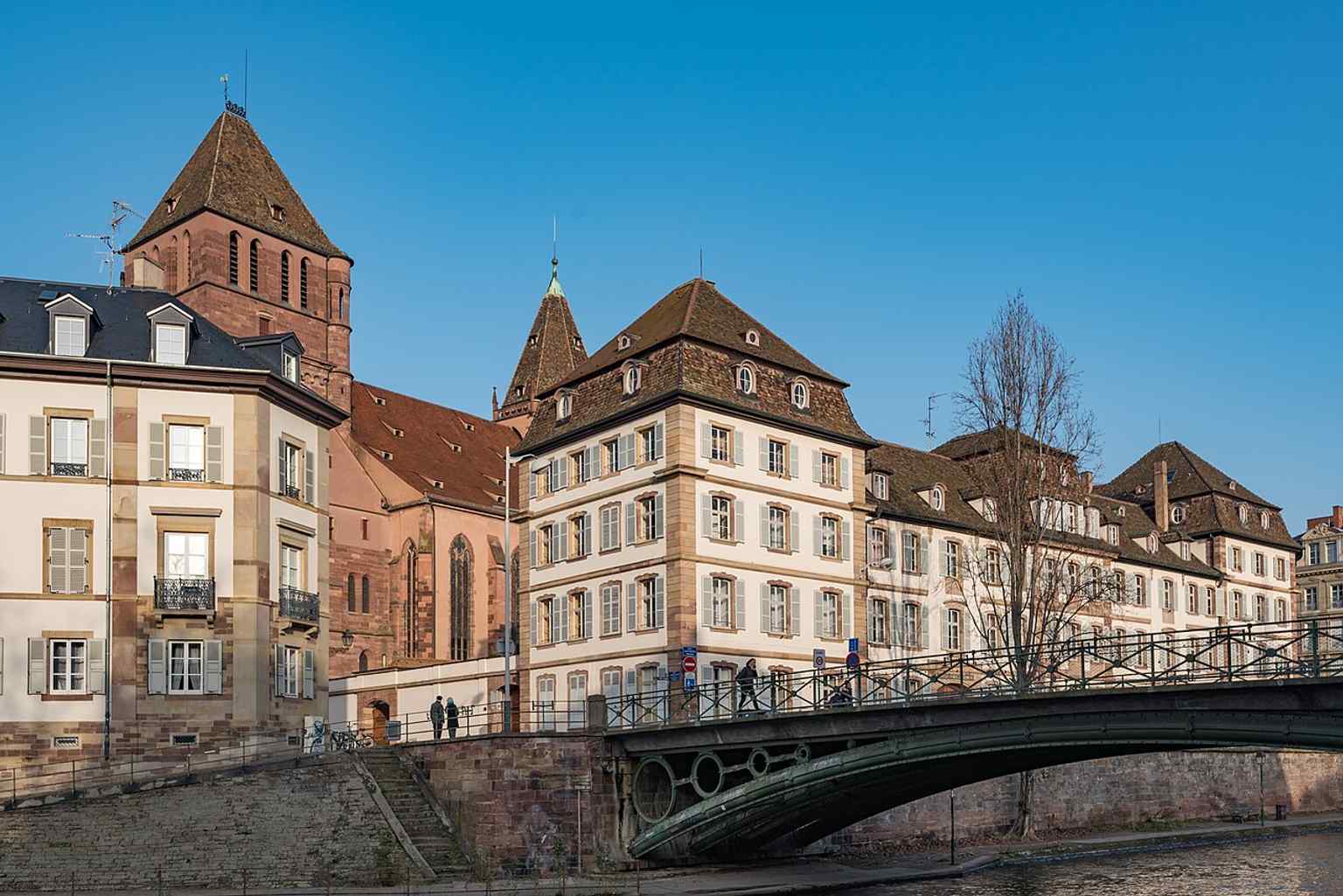 A wider view from the Quai Saint-Thomas, helping place the church beside the riverfront and the Petite France area.