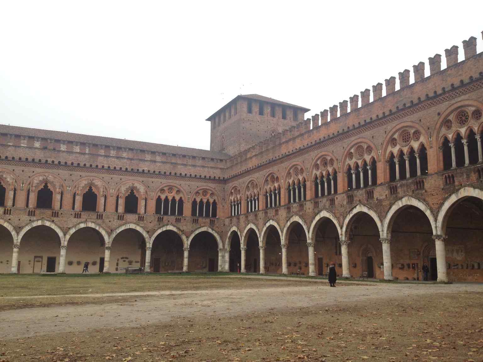 The internal courtyard's elegant porticos, supported by powerful stone columns, reflect the refined Gothic taste of the Visconti court.