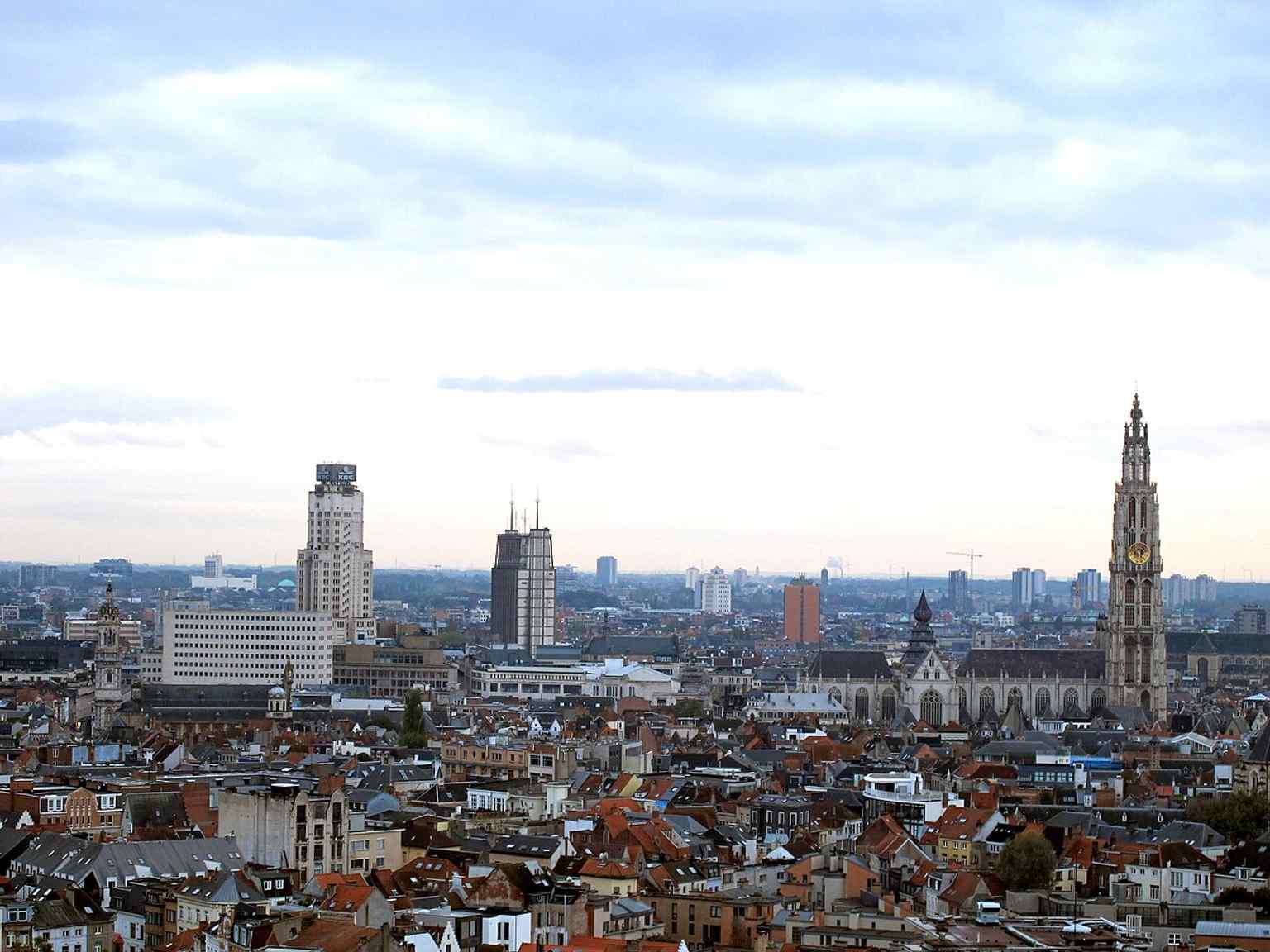 A panorama of Antwerp with the Boerentoren on the horizon, contrasting it with the cathedral and the rest of the city skyline.