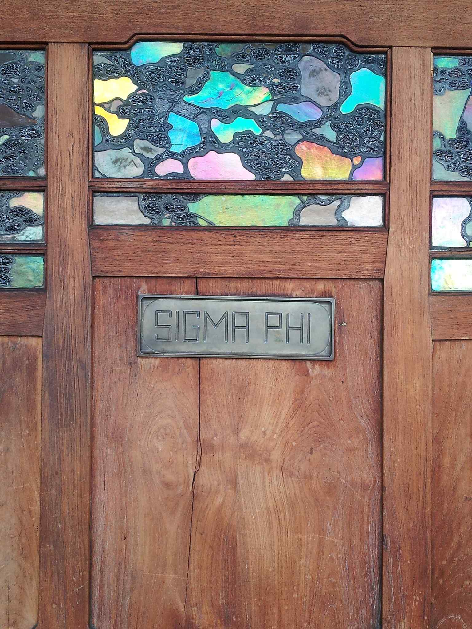 The front door entrance shows the house’s signature leaded art glass, including the vine motif tied to Greene & Greene’s refined wood-and-glass design.