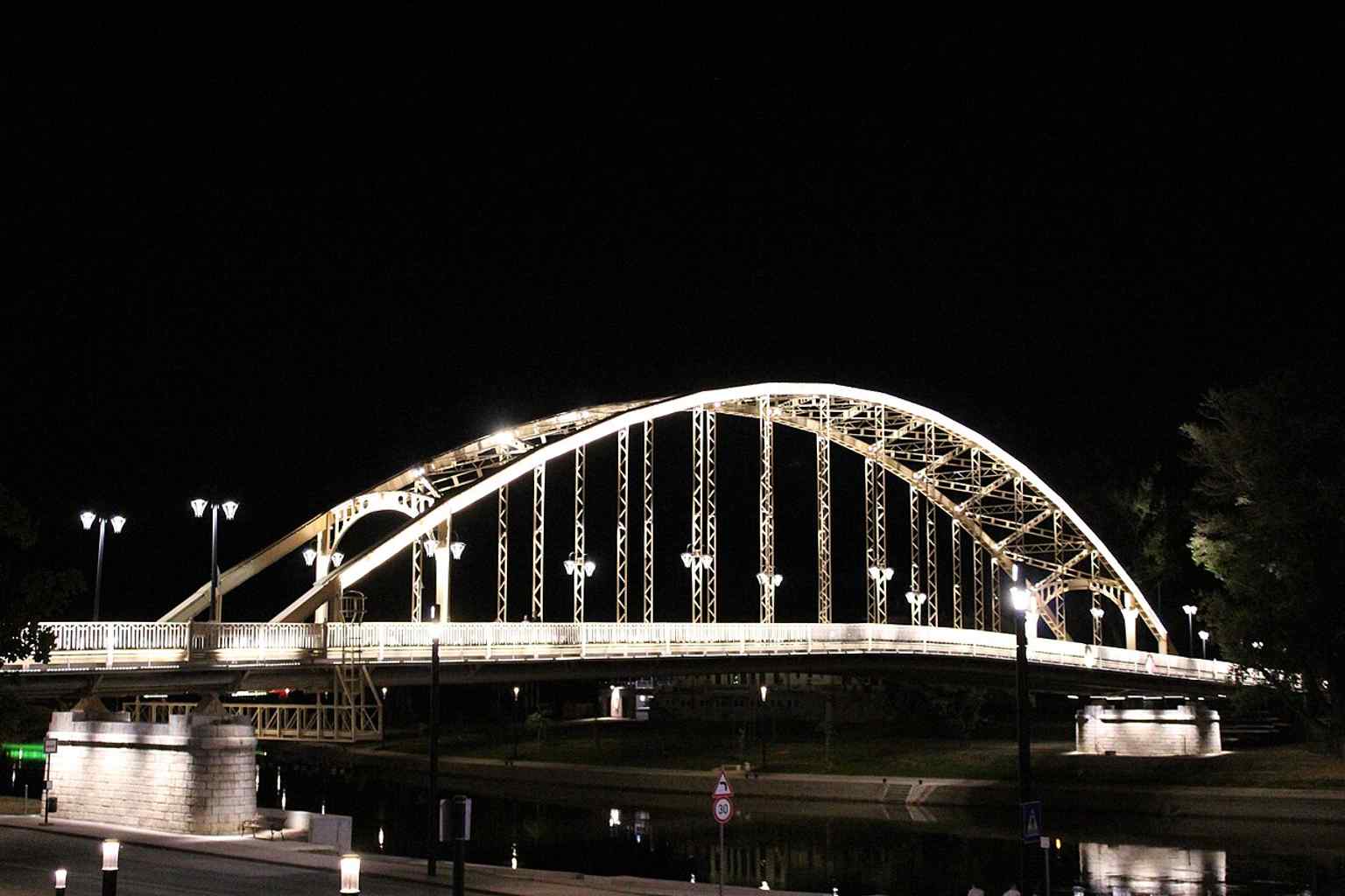 Kossuth Bridge illuminated at night, matching the landmark’s distinctive decorative lighting mentioned in the source text.