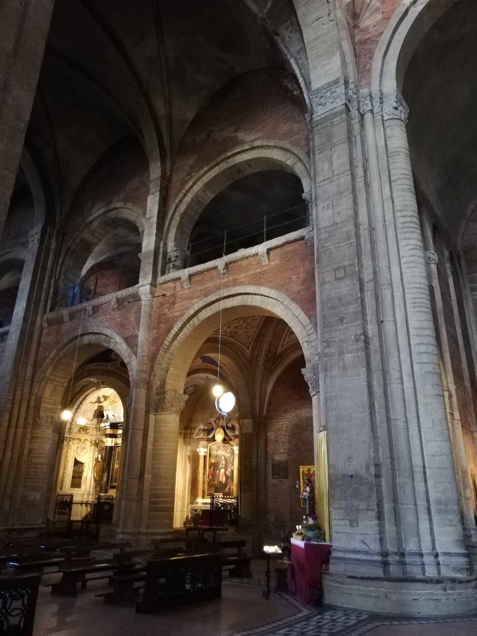 The expansive interior of the basilica, notable for its Latin cross plan and the exceptionally developed transept, a unique feature in Italian Romanesque architecture.