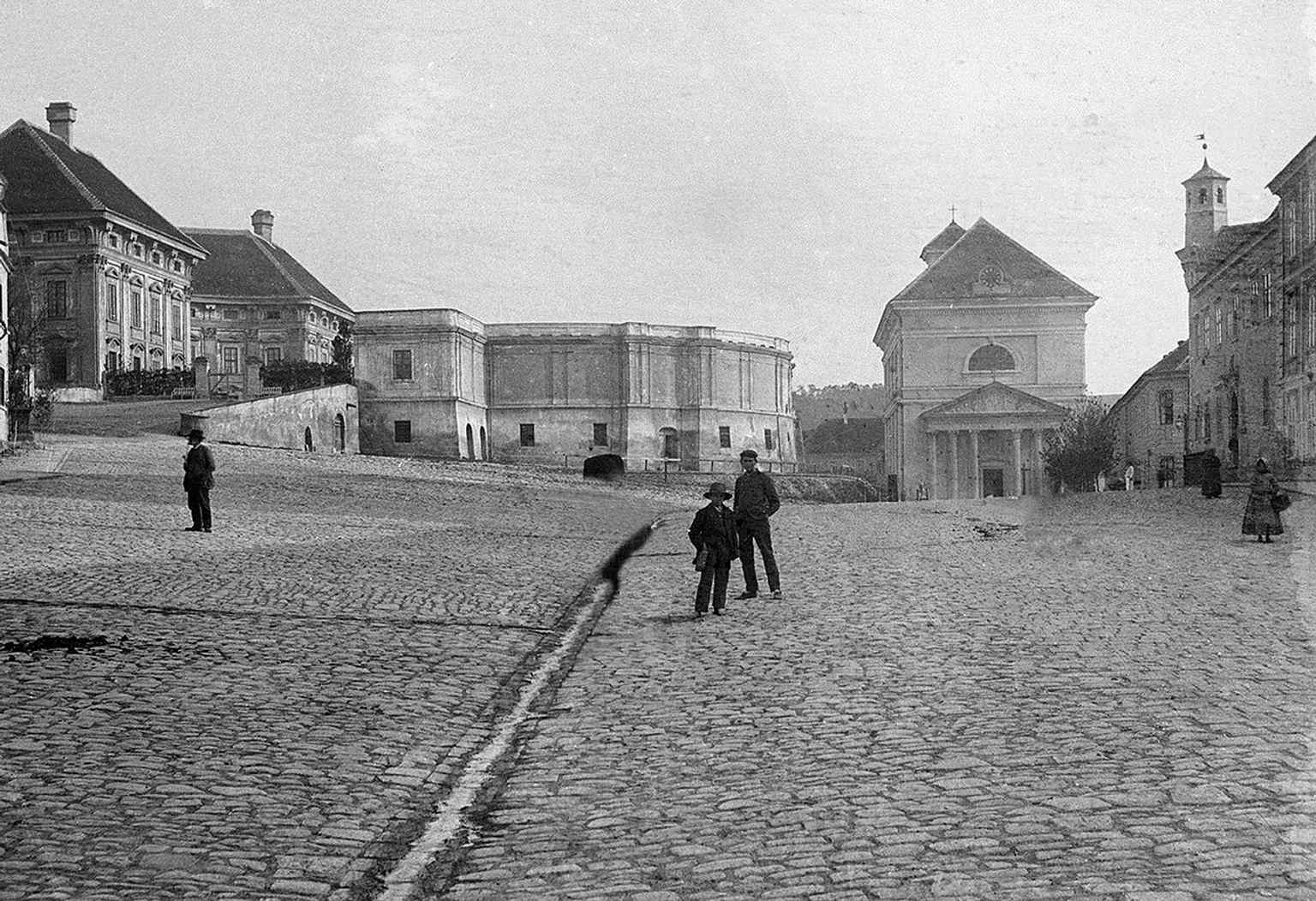 An 1895 photograph from the south captures the Baroque castle, its stables, the Neoclassical church, and the town hall with its distinctive turret, showcasing the square's major architectural elements.
