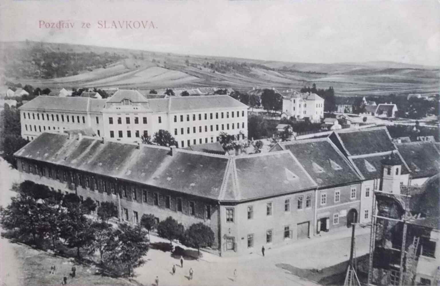 An early 20th-century postcard shows Palackého náměstí, highlighting the old general school building, which was constructed in 1862 and later housed part of the municipal office.