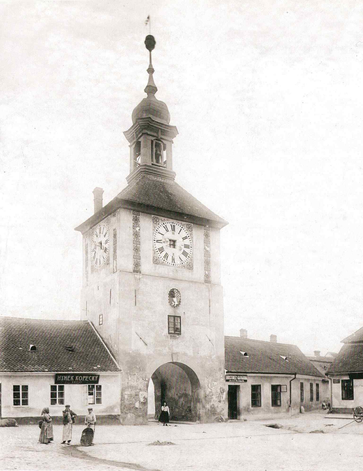 This late 19th-century photograph captures a detailed view of the Hodinová brána (Clock Gate) from the northeast, before its demolition in 1903, serving as the southern entrance to Palackého náměstí.