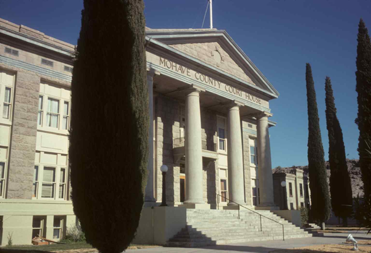 The Neoclassical Mohave County Courthouse and the jail complex in the background, photographed in 1976.