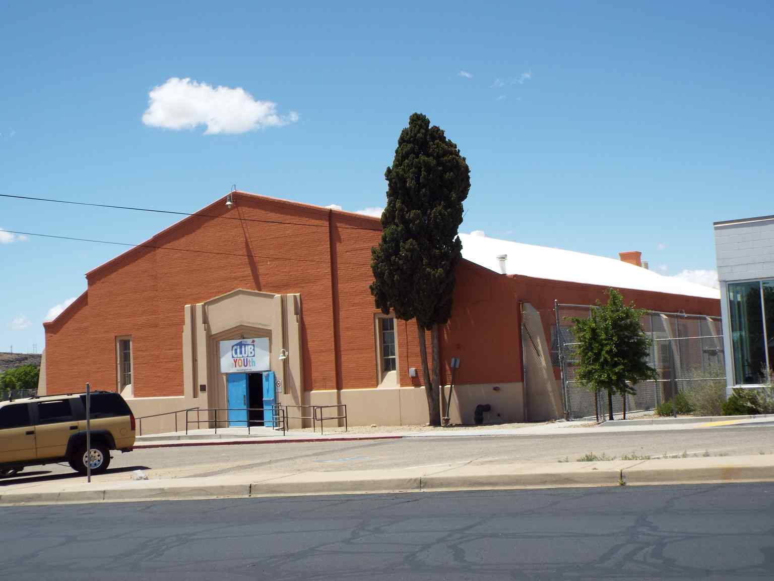 The Mohave Union High School Gymnasium features a classic gabled roofline and reddish-brown stucco, serving as a historical centerpiece. Photographed in 2019.
