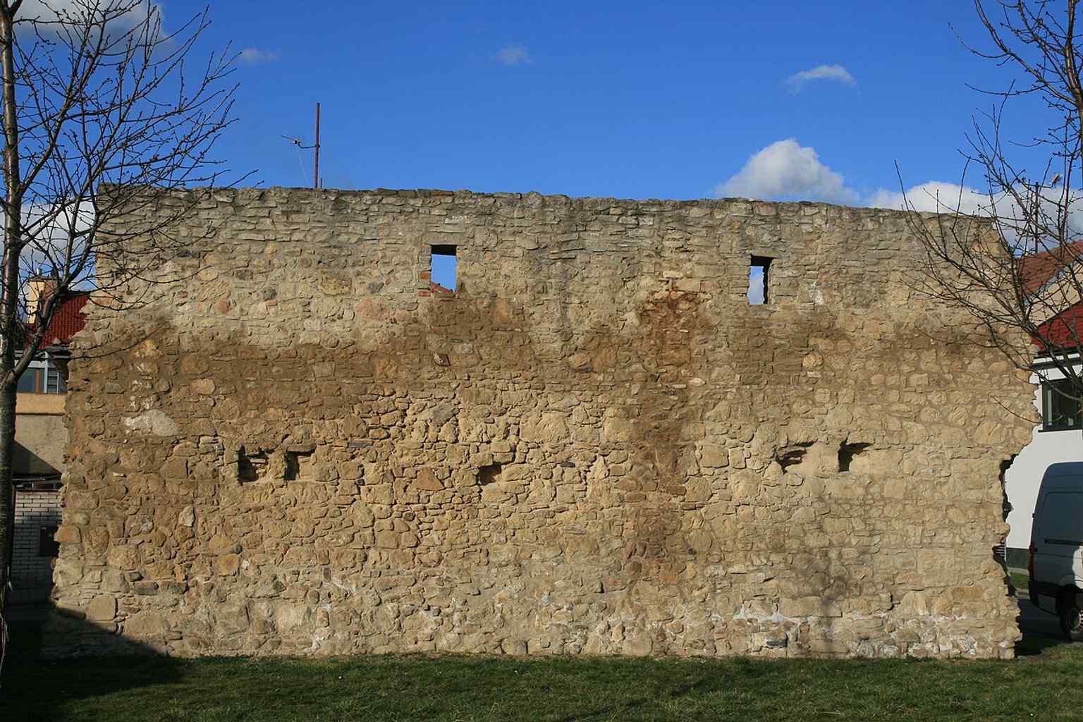 This fragment of the city walls is located at the intersection of B. Němcové, Zborovská, and Hradební streets, near where the southern Rybničná (Clock) gate once stood.