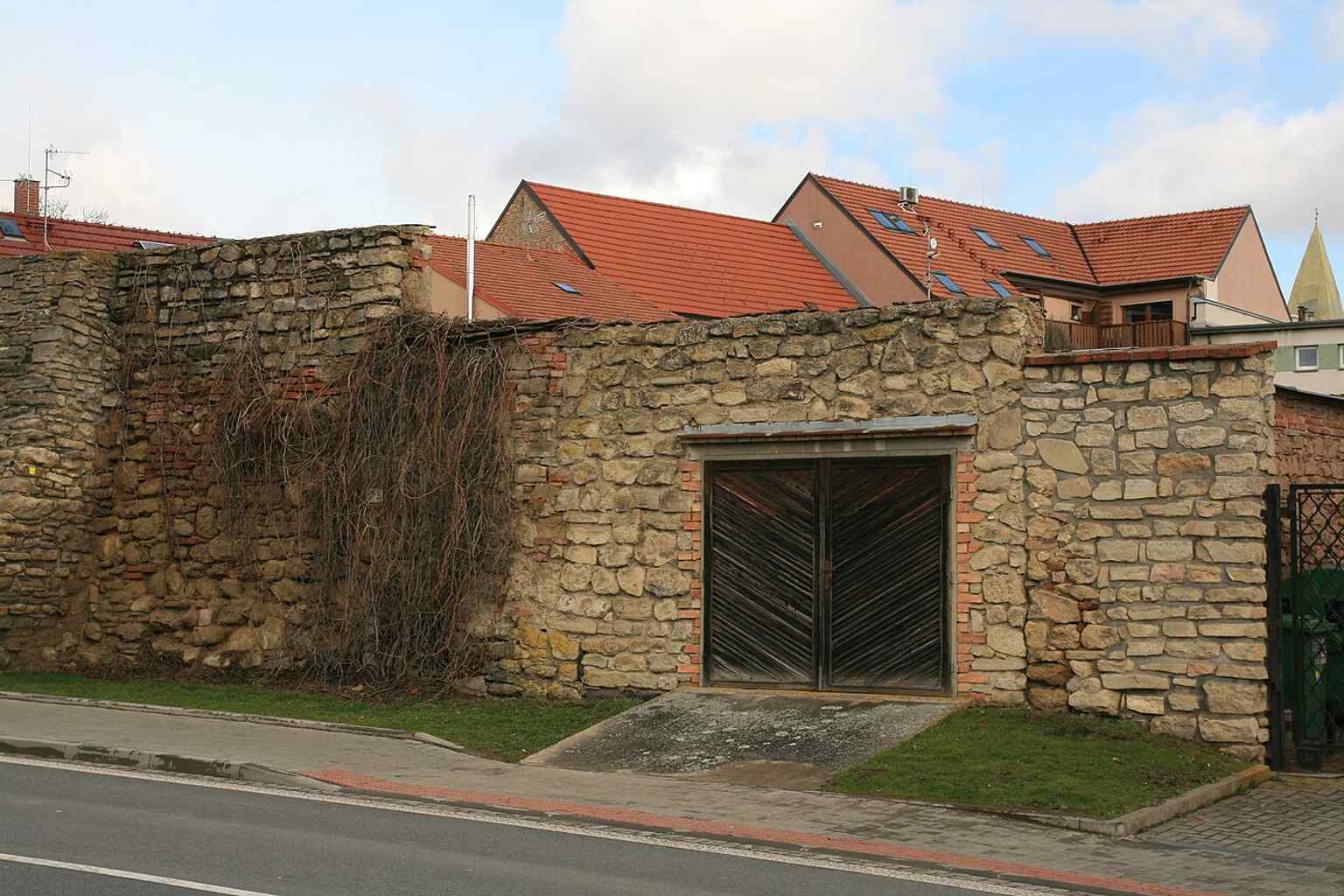 This image highlights a garage built directly into the medieval city wall, an example of "insensitive additions" that prompted calls for preservation in the late 20th century.