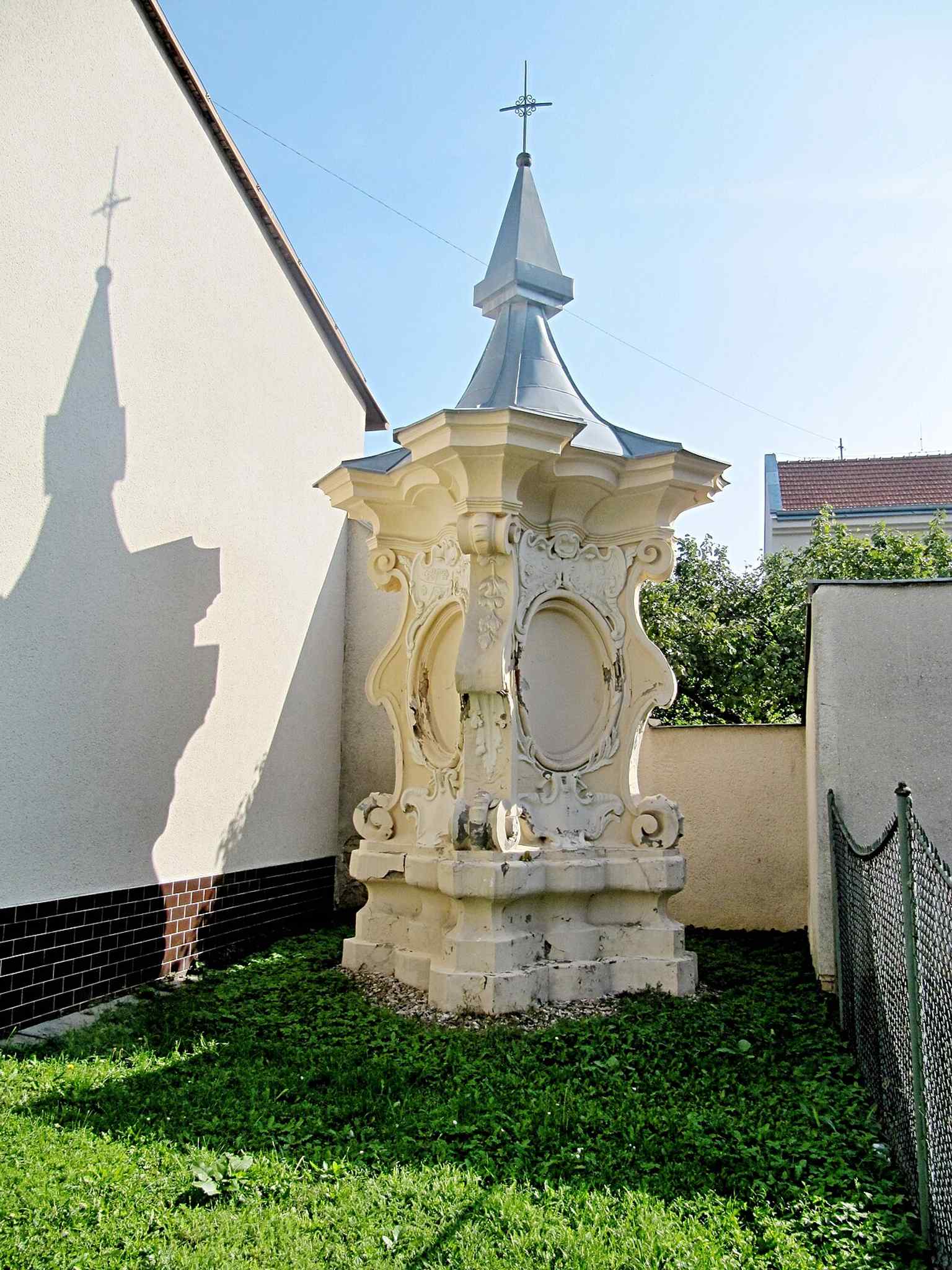 This late Baroque pillar, a cultural monument since 1970, features valuable stucco decorations including the combined coats of arms of the Kounic and Rietberg families, commemorating the 1699 marriage of Maxmilián Oldřich and Marie Arnoštka, whose union inspired its creation.