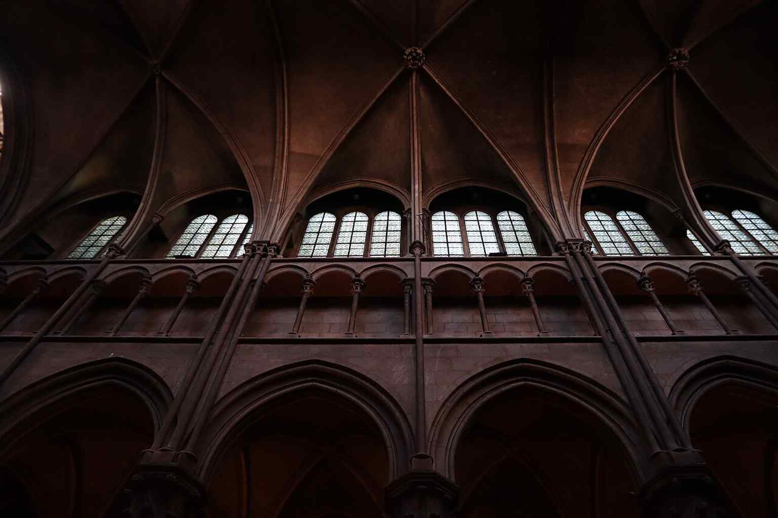 The impressive nave, featuring three stories of elevation and sexpartite vaults, designed to create a monumental impression within the church's relatively modest space.