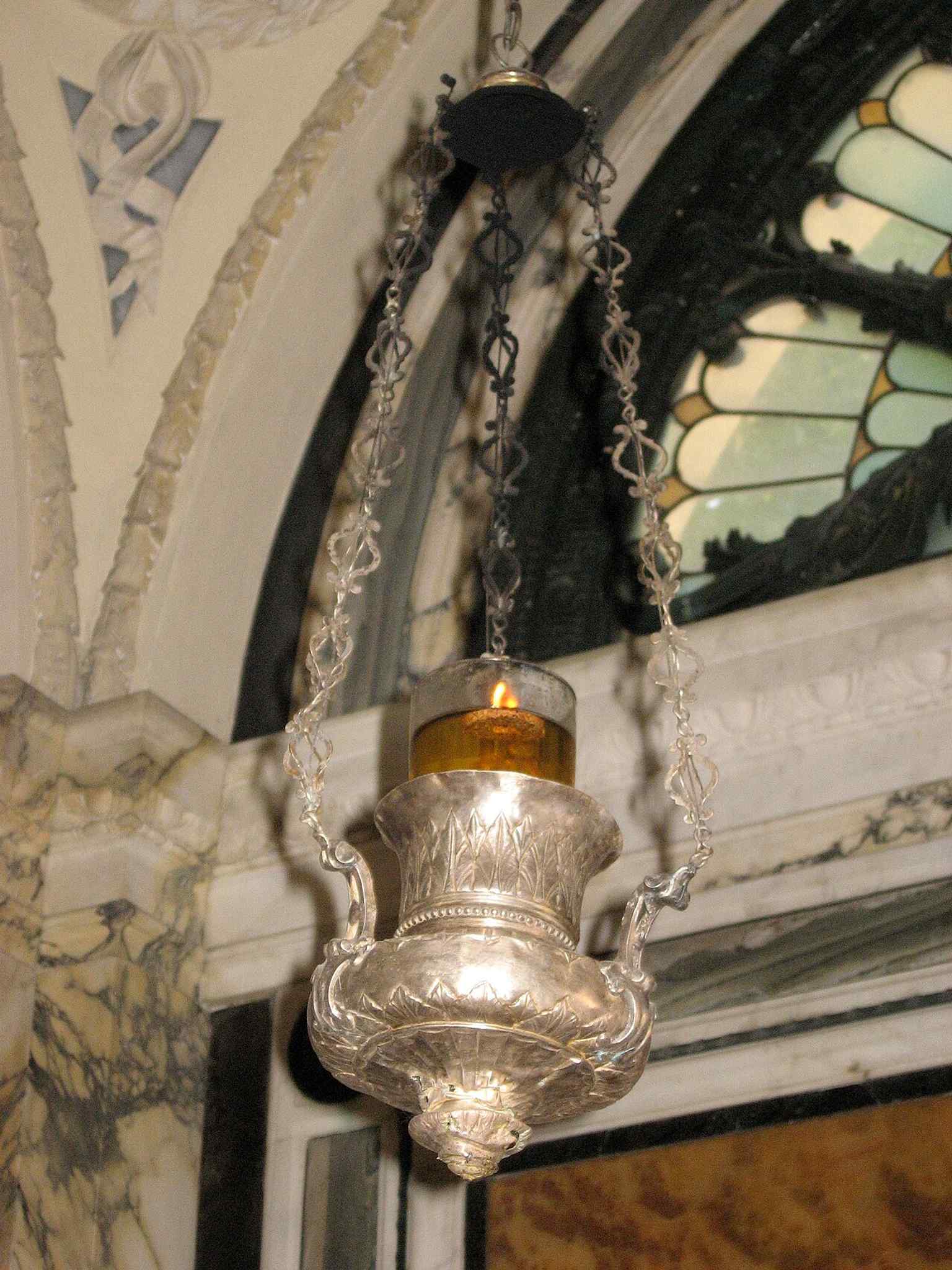 The perpetual oil lamp inside the chapel, lit with olive oil from Tuscany in a long-running memorial tradition.