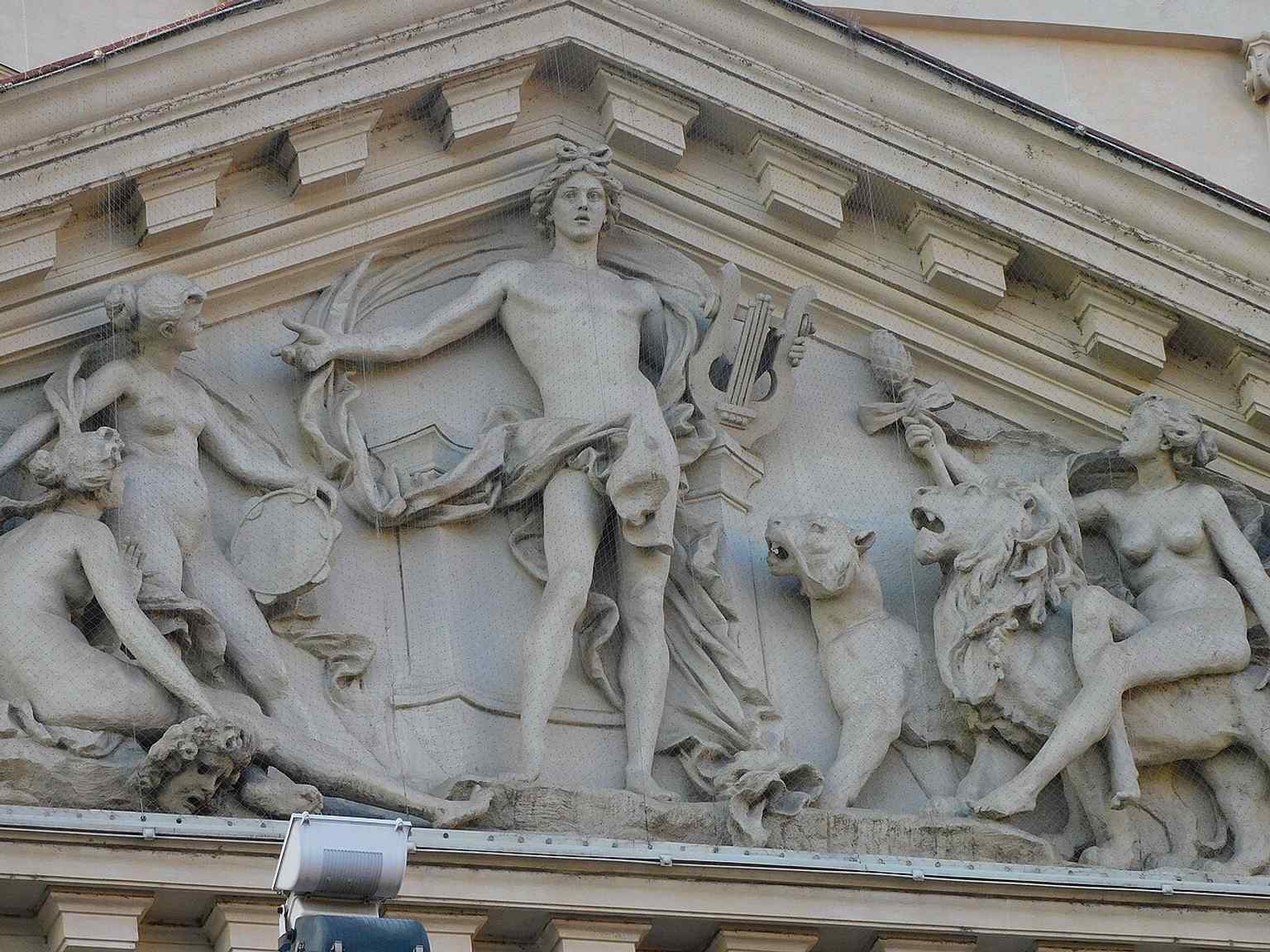 The south tympanum with Apollo and attendant figures — a sculptural program that links the building to music and the performing arts.