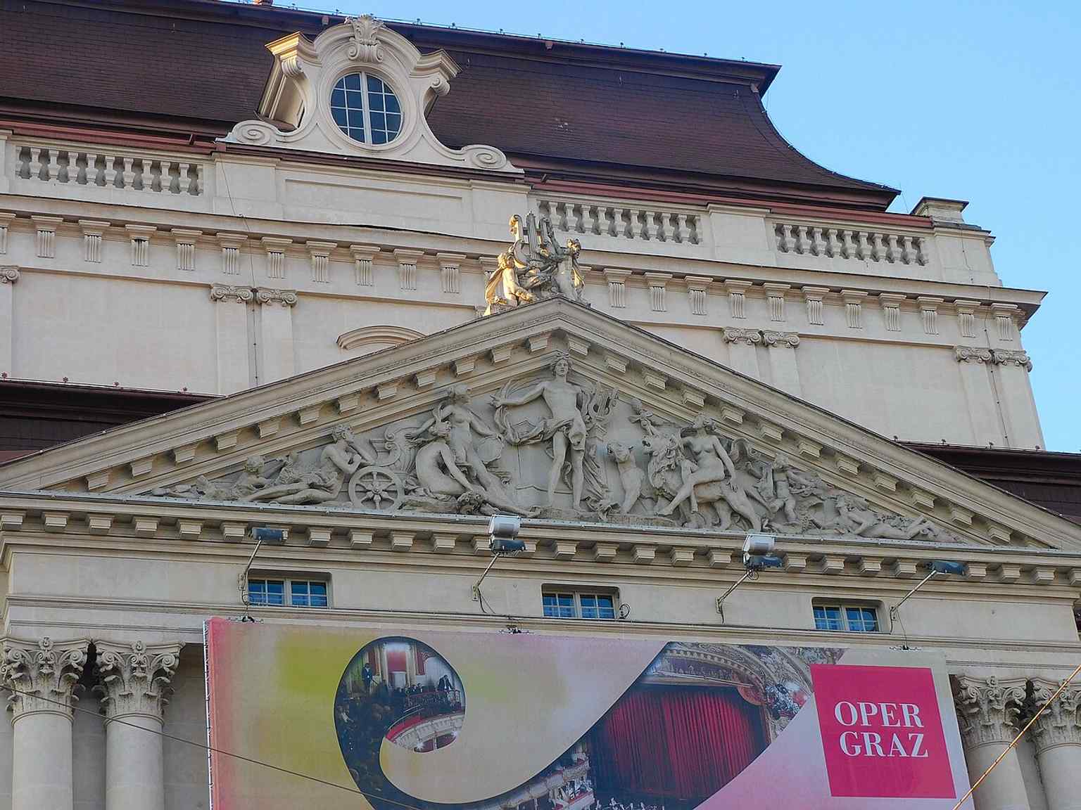 The Apollo relief on the south tympanum, a striking example of the opera house’s symbolic façade decoration.
