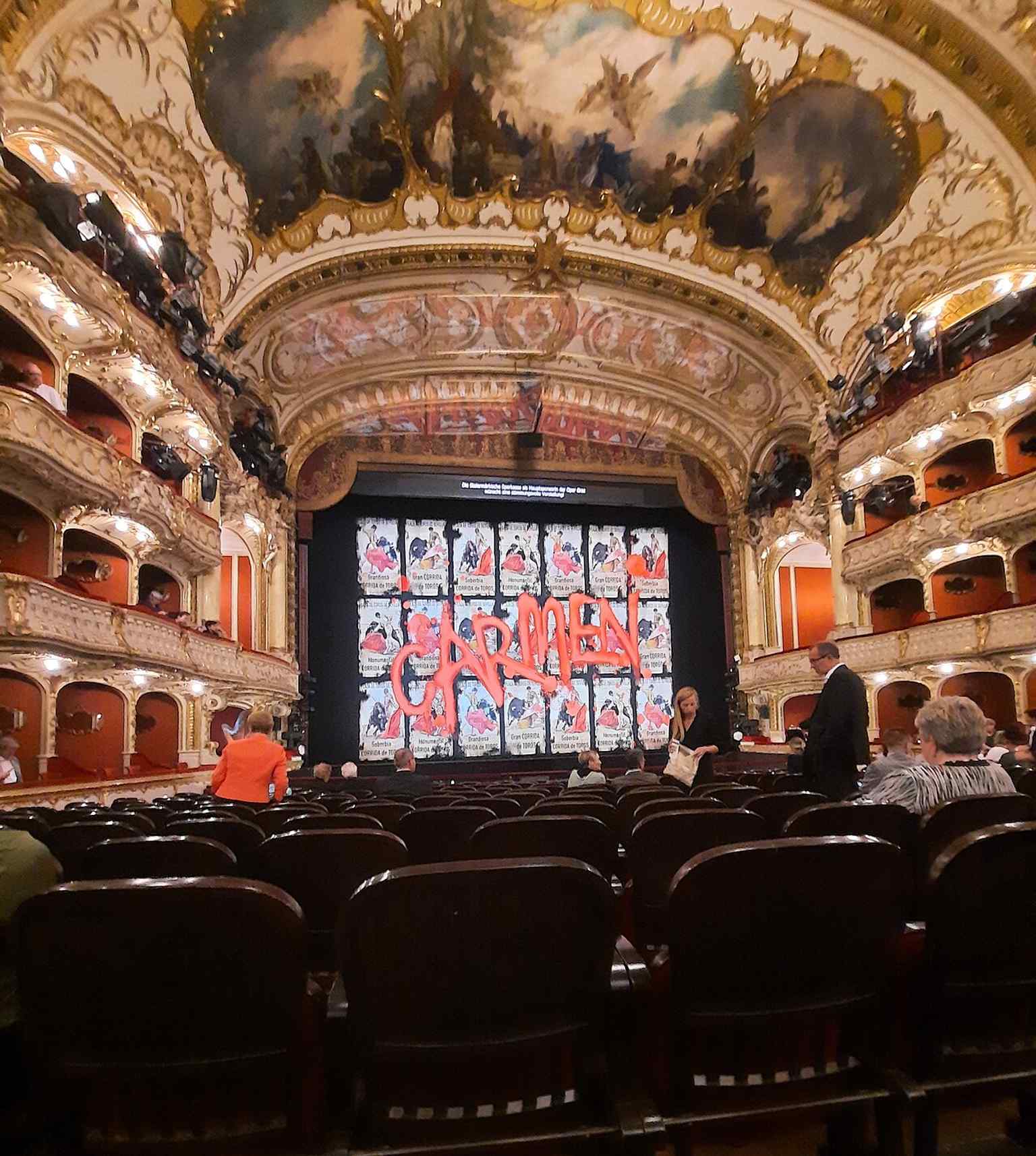 The auditorium before a performance, with the horseshoe layout and richly decorated seating area that gives the house its opulent character.