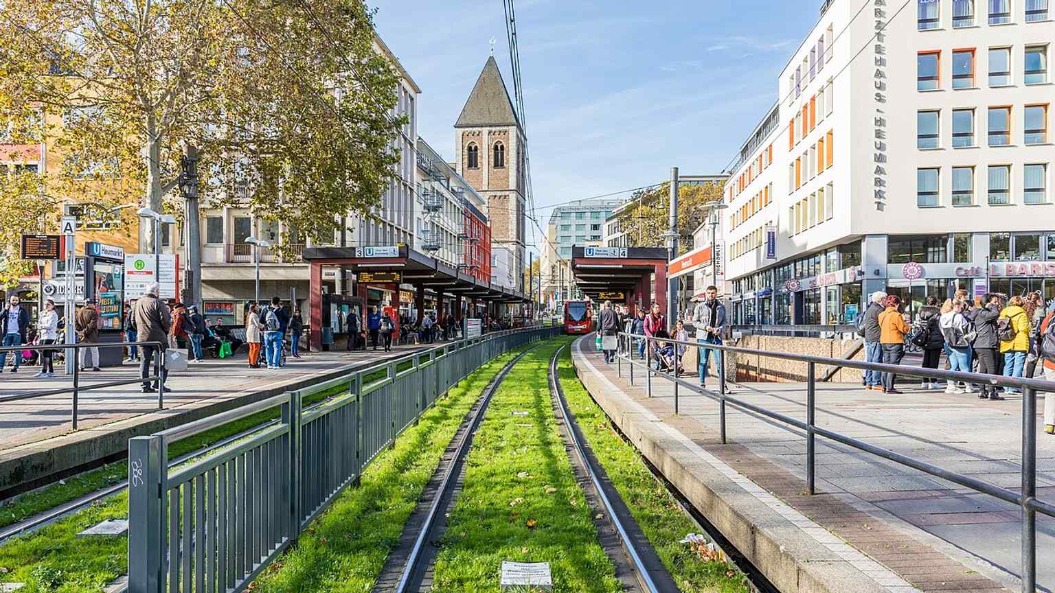 View of the Klein St. Martin tower rising above the modern Heumarkt area, where its former parish district once stretched to the Rhine and Marsplatz.