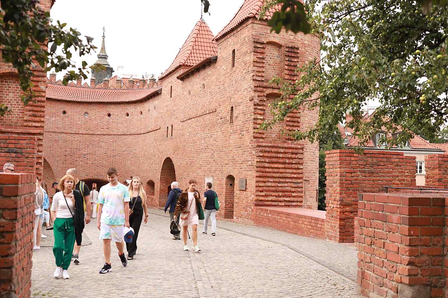 A broad modern view of the Barbican and adjacent walls, showing the rebuilt fortification as part of the Old Town fabric.