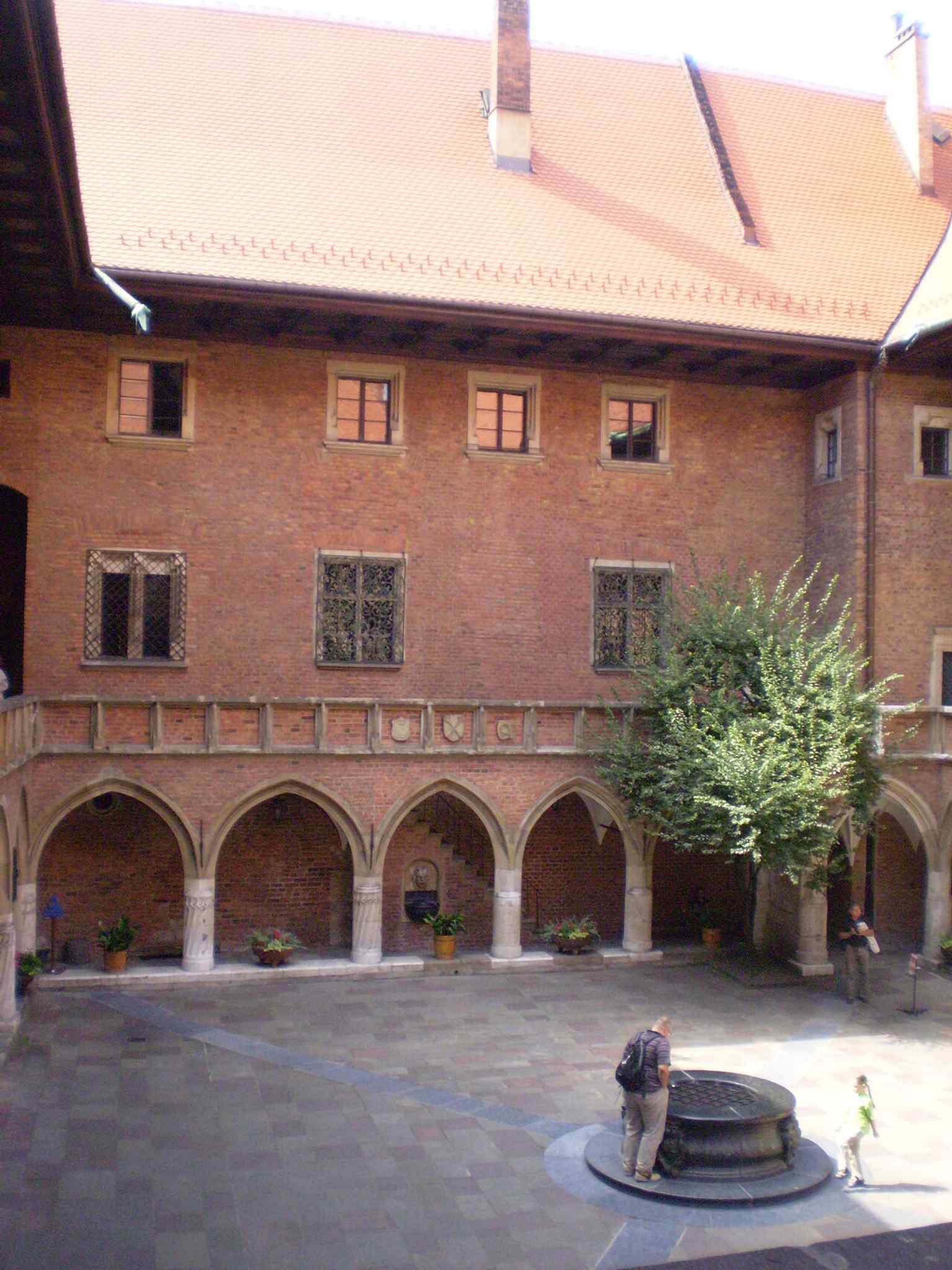 The courtyard well echoes the 1517 tradition of a well at the center of daily life in Collegium Maius.