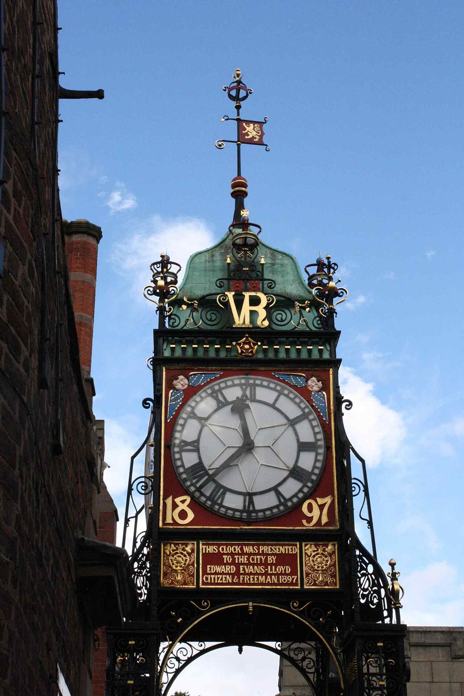 The south face of the clock, showing the ornate Victorian details and the copper cupola that crowns the tower.
