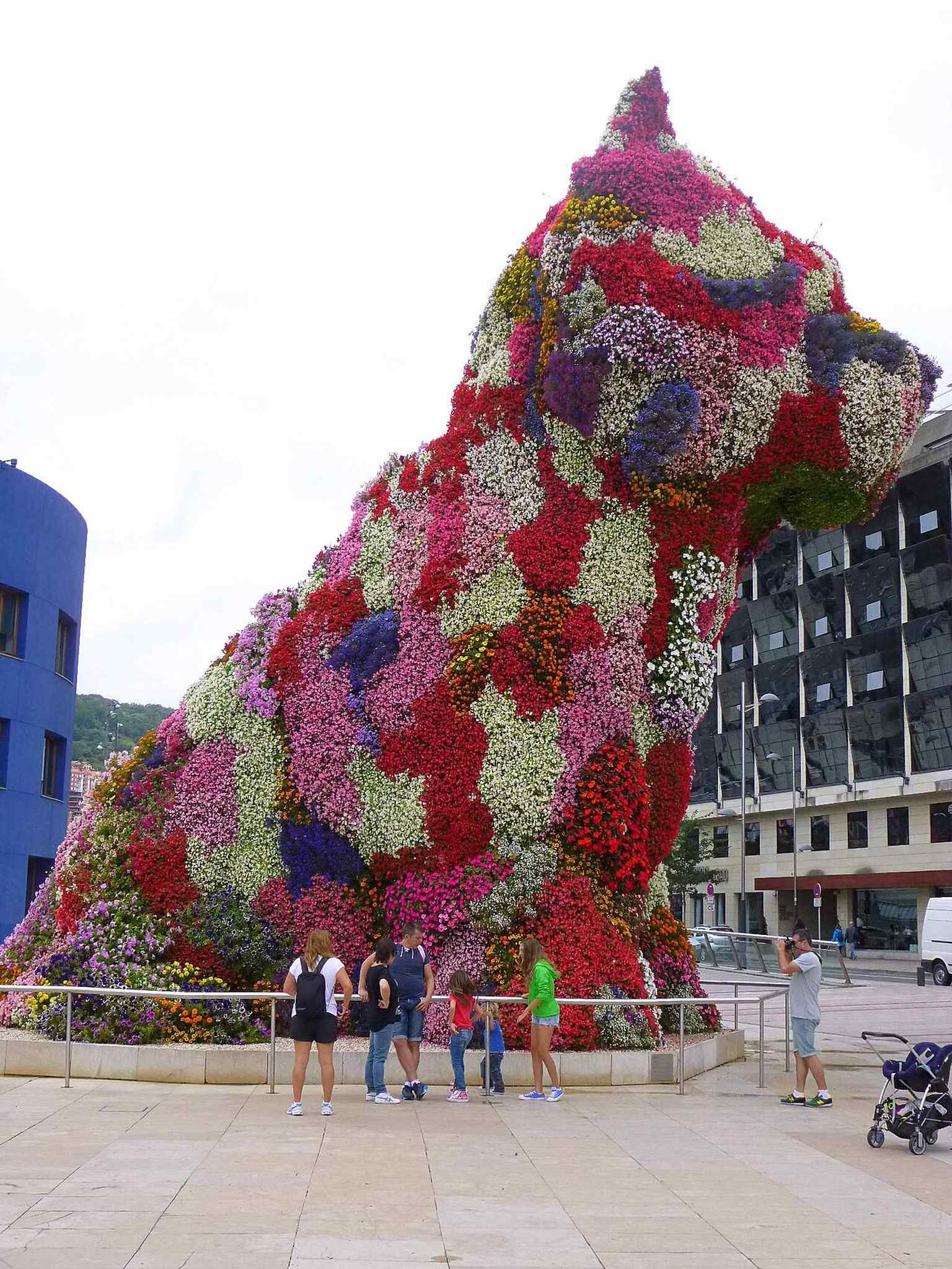 A clean mid-distance view of Puppy on the museum terrace, good for showing the sculpture’s proportion and placement.