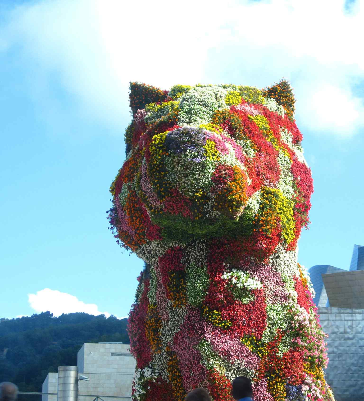 A dramatic, artful view of Puppy that captures its cheerful, almost theatrical presence — exactly the optimistic image Koons wanted.