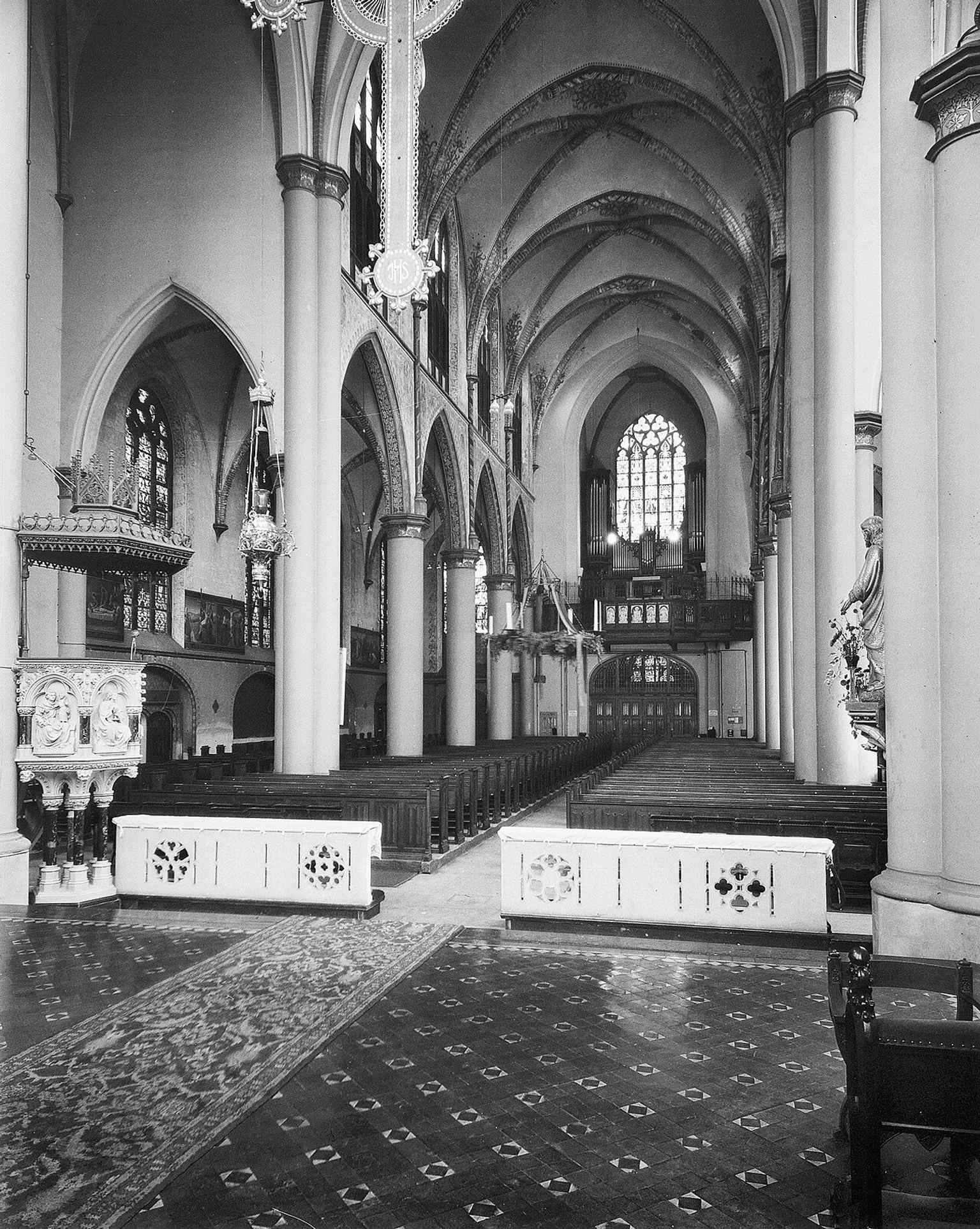 The interior view toward the organ highlights the liturgical axis of the church and connects directly to the historic Gradussen organ.