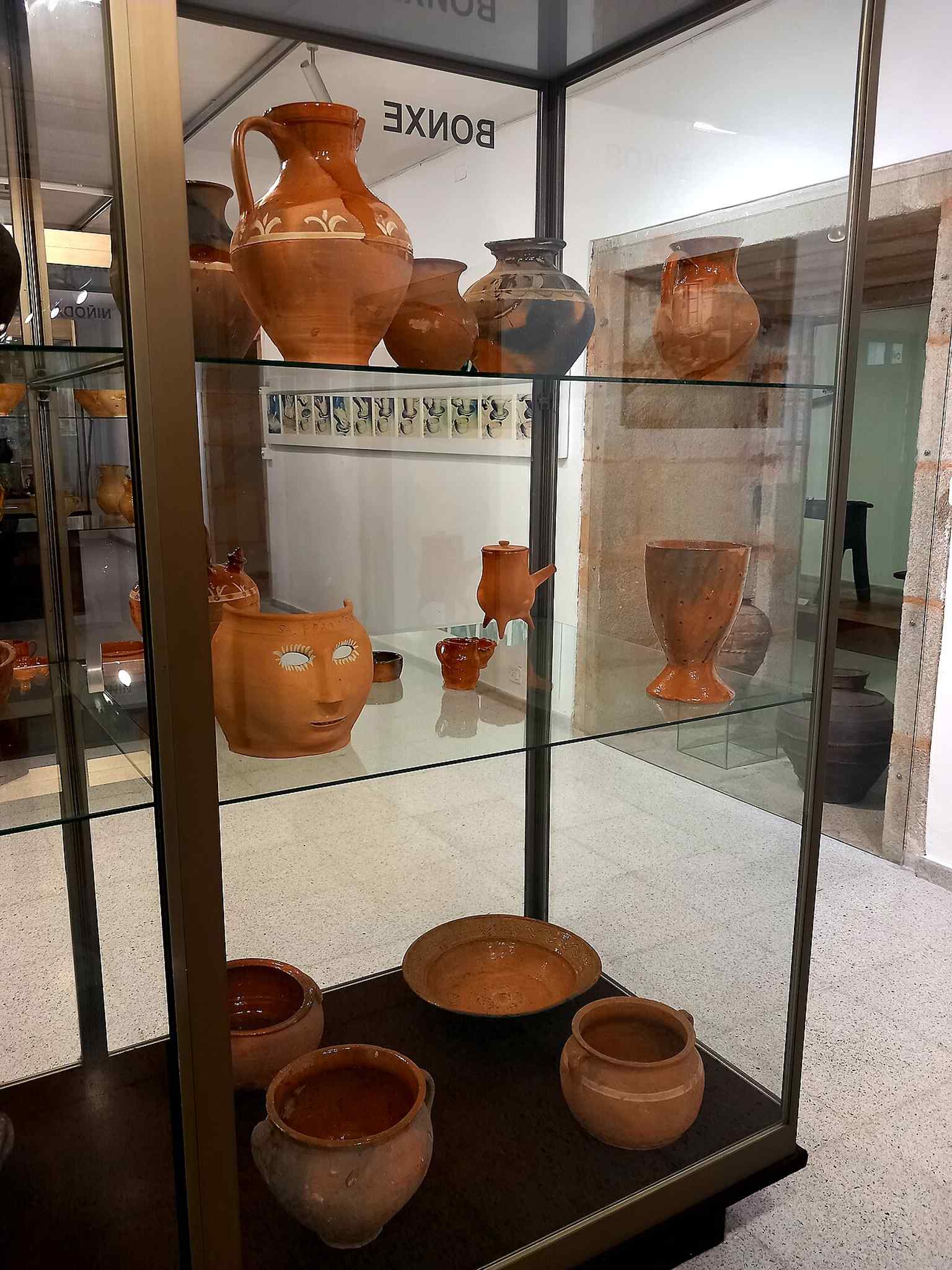 An exhibit of traditional pottery from Bonxe, part of the museum's 'Sala de la Olería,' which houses collections assembled by dedicated individuals like Luciano García Alén and his wife.