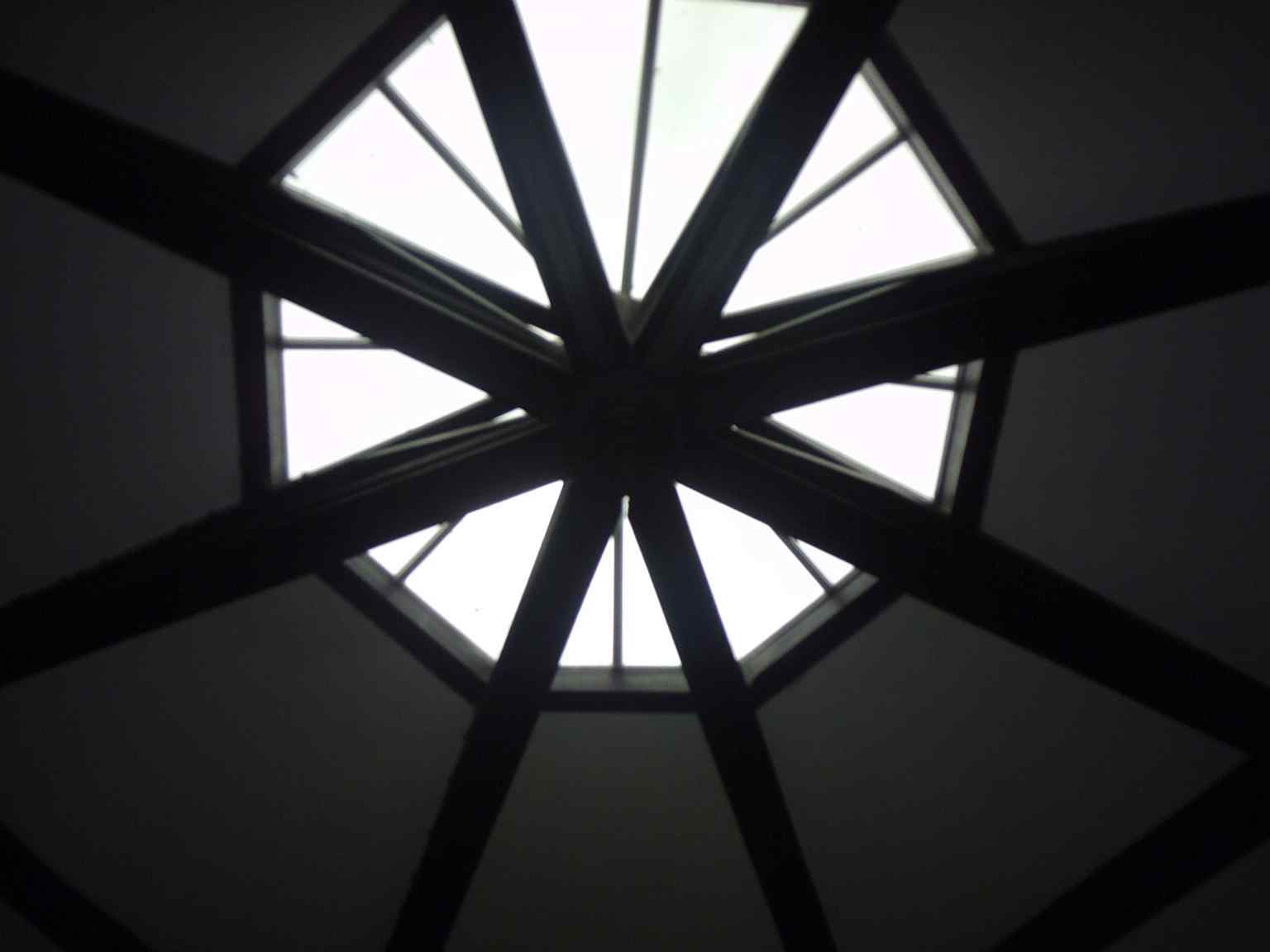 The skylight and exposed beams reveal the tower’s interior roof structure above the older stone chambers.
