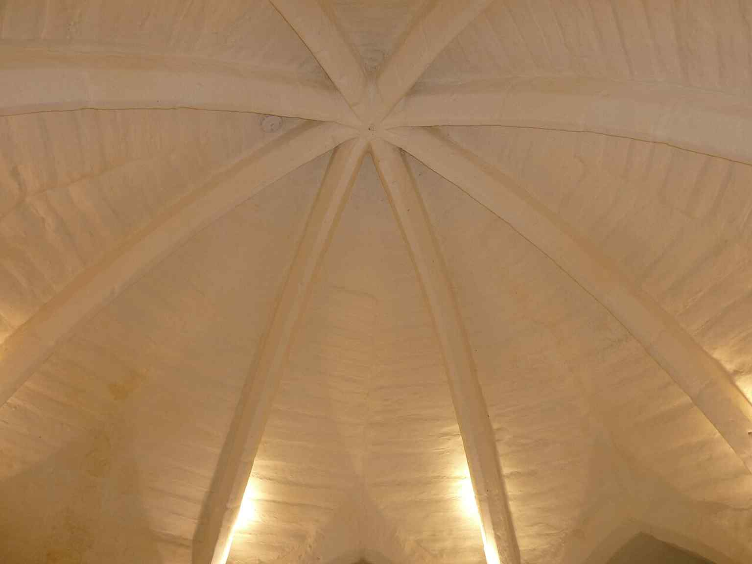 The arched ceiling in the lower chamber, showing the thick sandstone structure of the medieval tower.