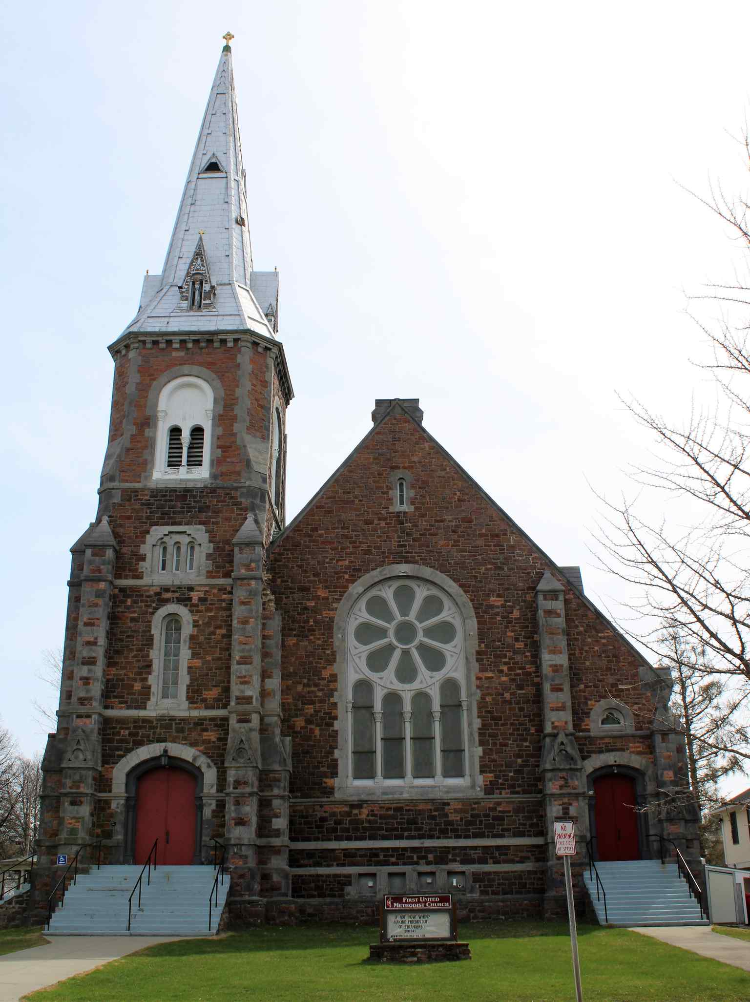 Observe the distinctive masonry of the church, built with purplish Willard's Ledge stone and trimmed with lighter grey sandstone from the Isle La Motte quarries, a deliberate contrast in materials.