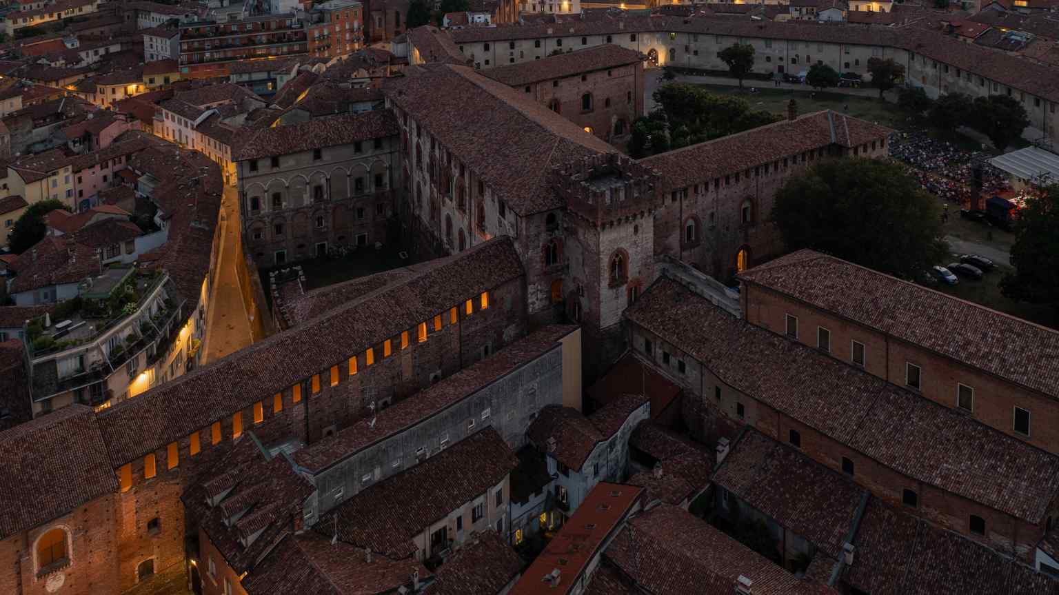 This wide view captures the extensive complex of buildings that form the Castello Sforzesco, sprawling over 70,000 m² and encompassing various architectural styles developed over centuries.