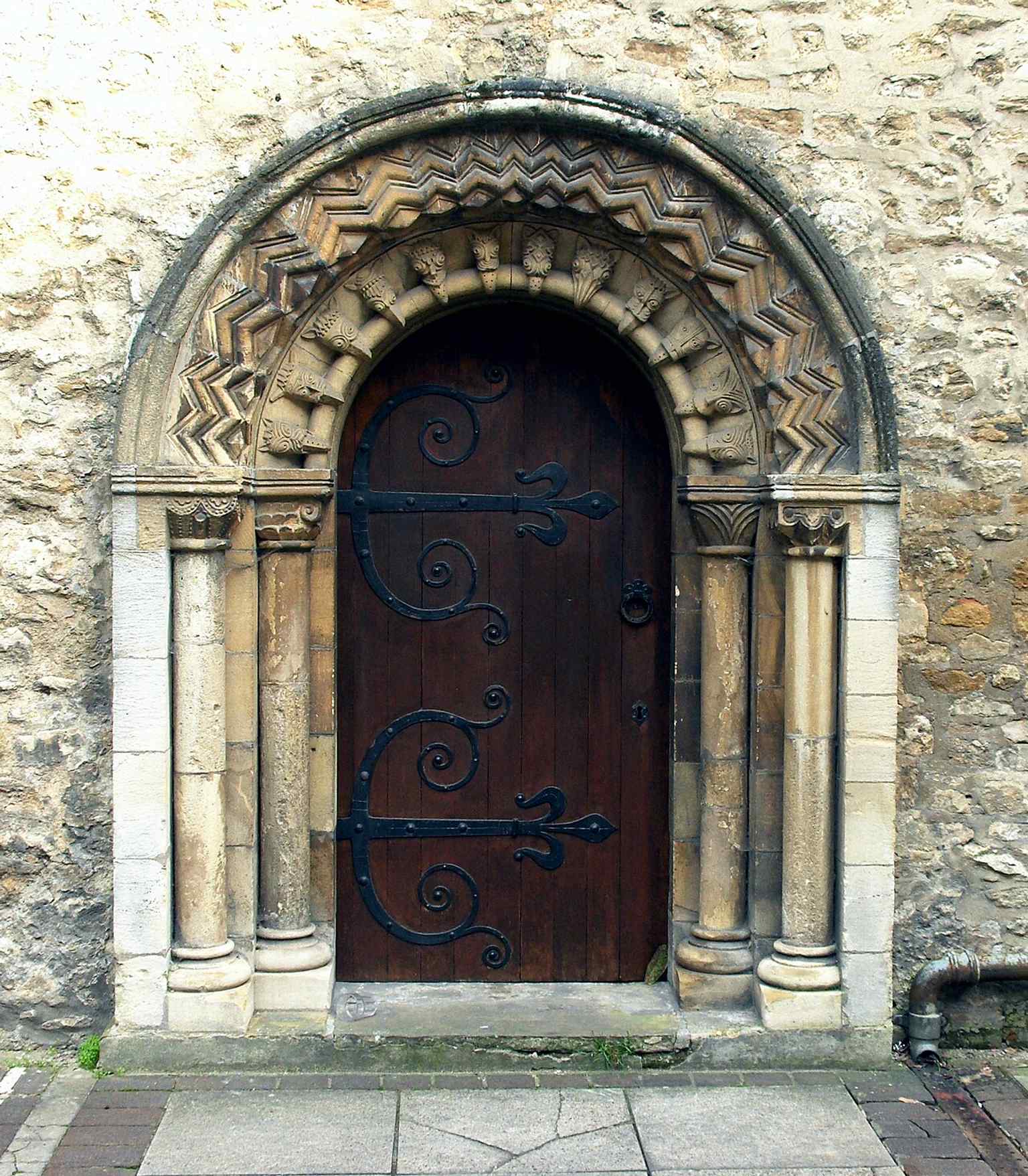 The restored 12th-century Norman west doorway — a rare surviving medieval feature on a church otherwise rebuilt in the 1814–16 period.