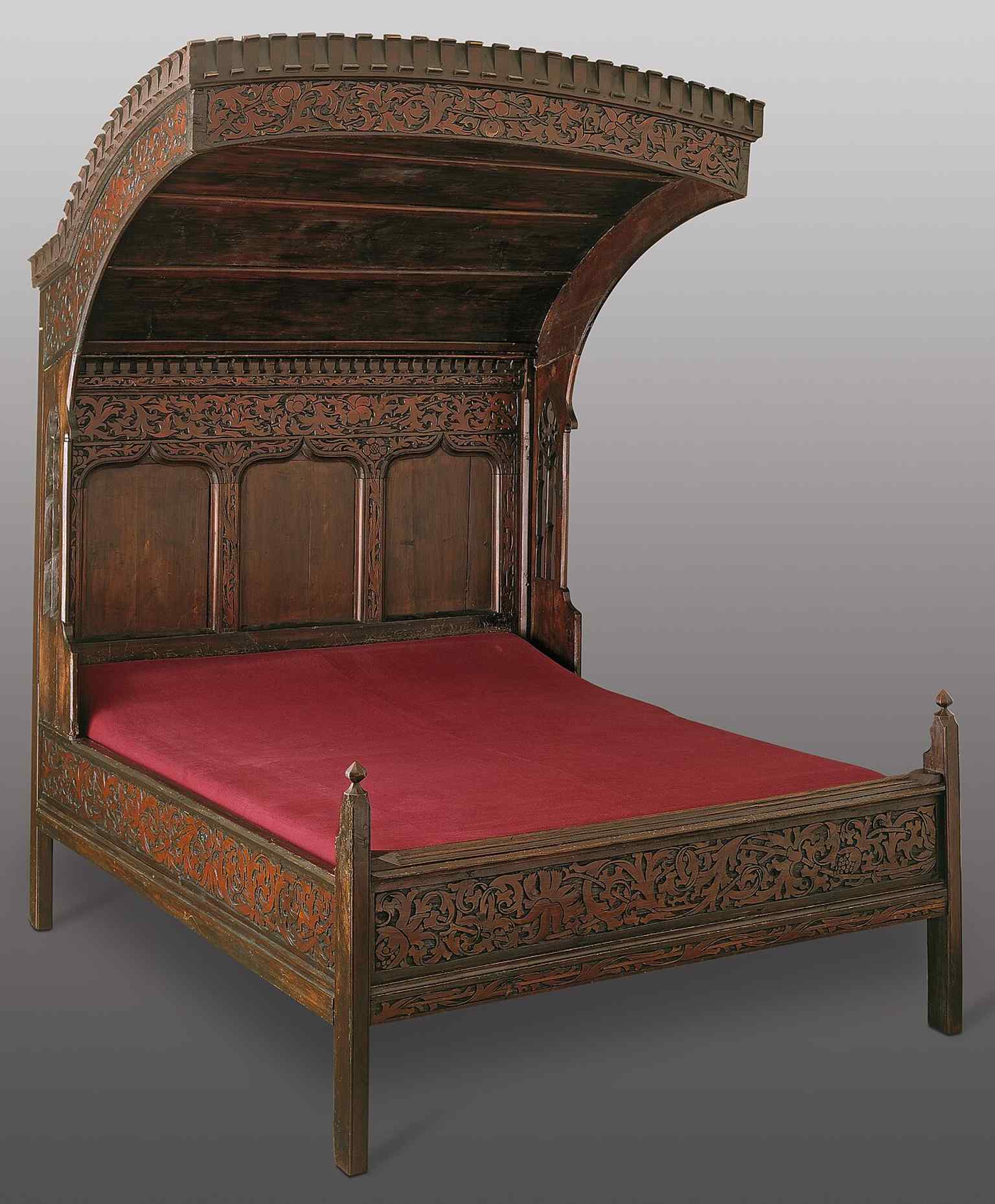 A medieval carved bed from a former monastery interior, matching the museum’s focus on everyday life and historic furnishings.