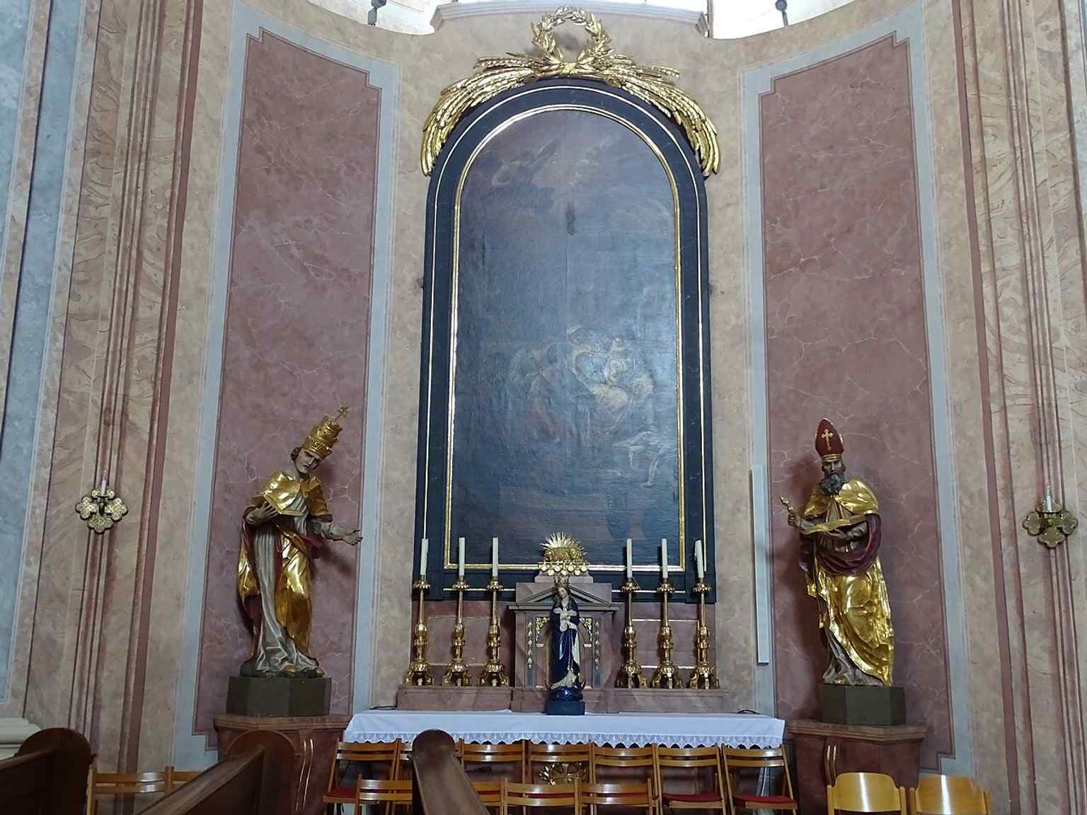 The left side altar, showing the rich devotional interior beyond the main altar and organ.