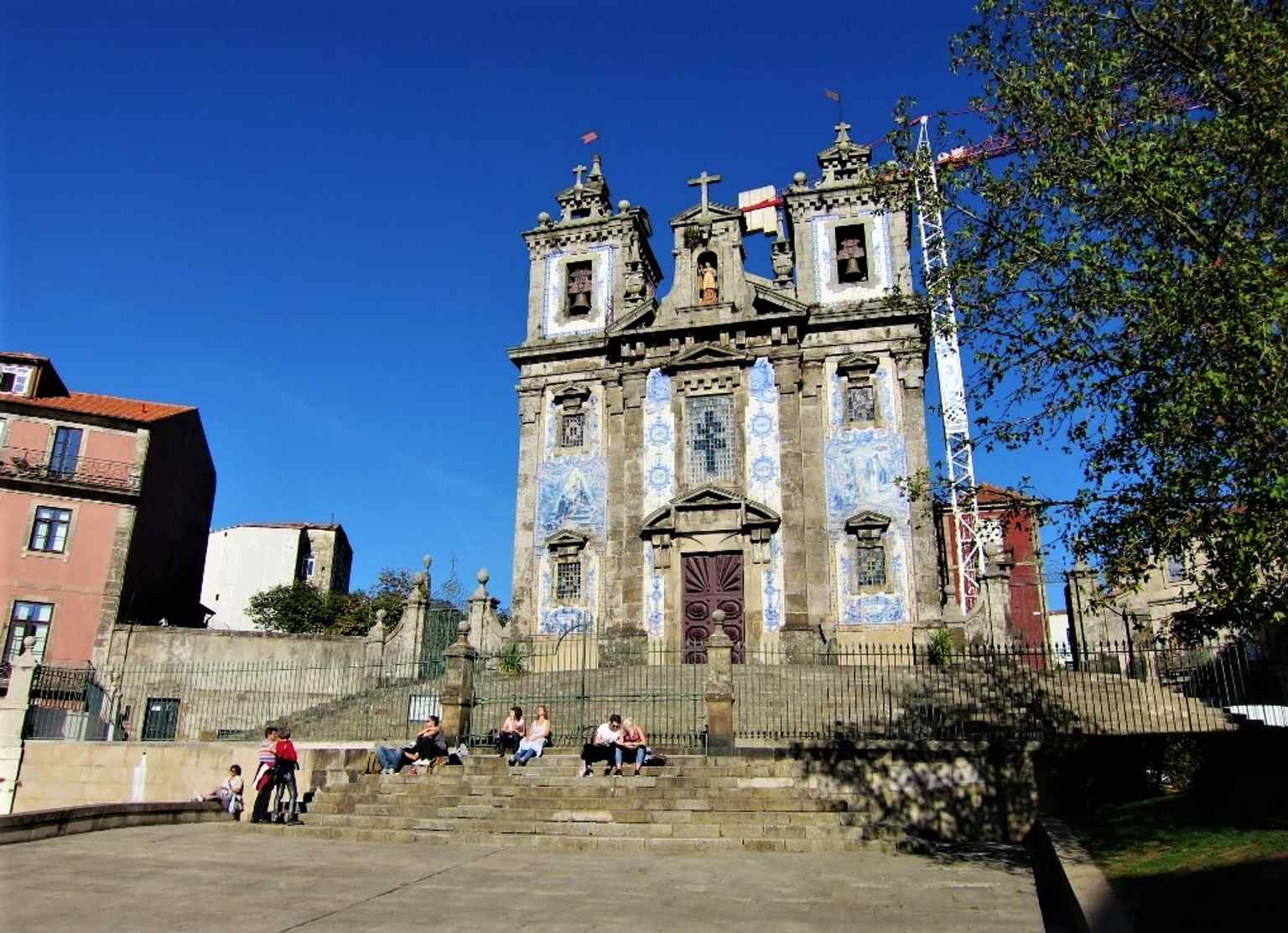 Seen from Batalha Square, this view places the church in its busy urban setting near Porto’s historic pedestrian heart.