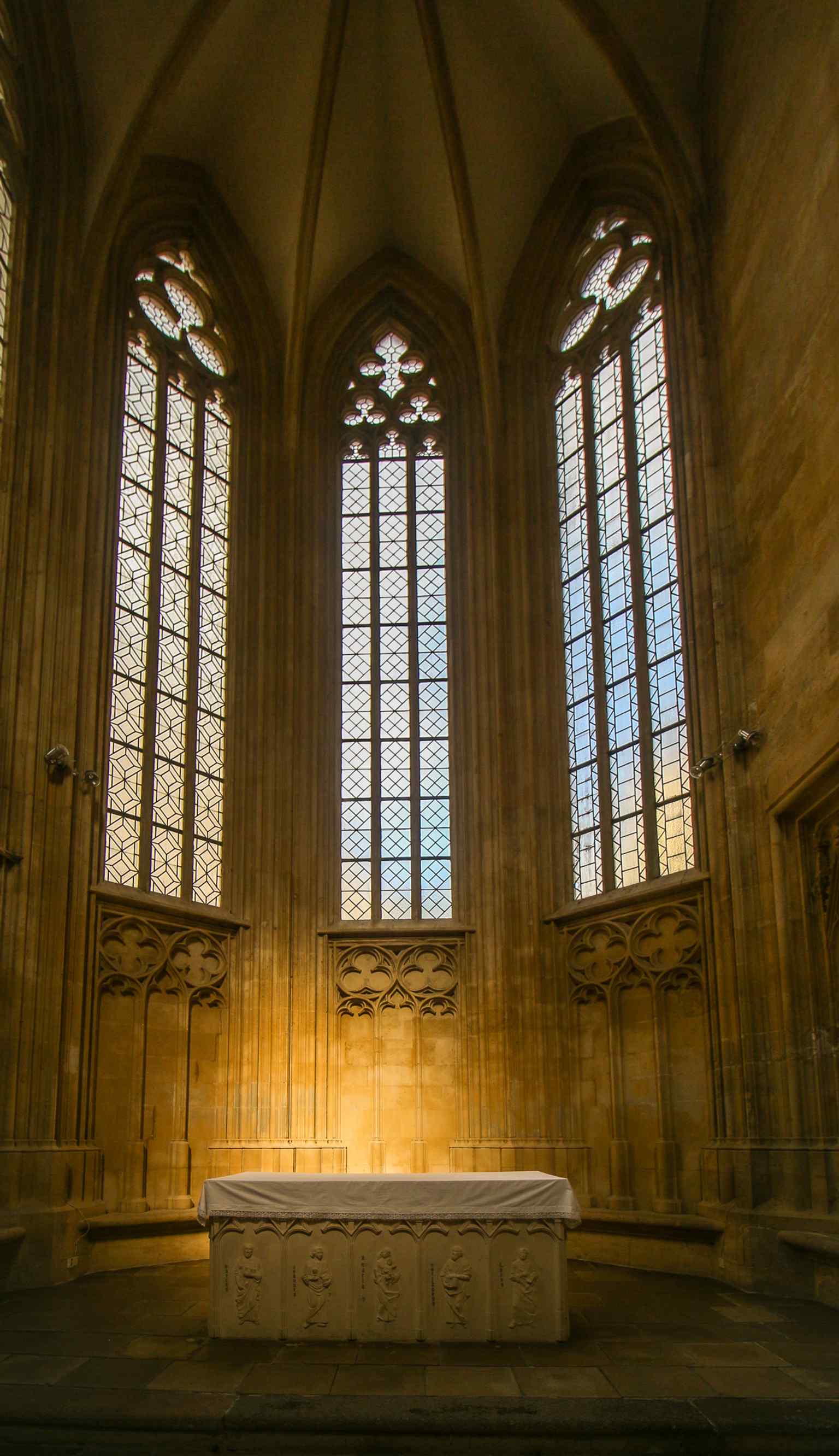 The altar in the Chapel of Saint John the Evangelist, a key Gothic side chapel later restored and fitted with a new altar table and saintly figures.