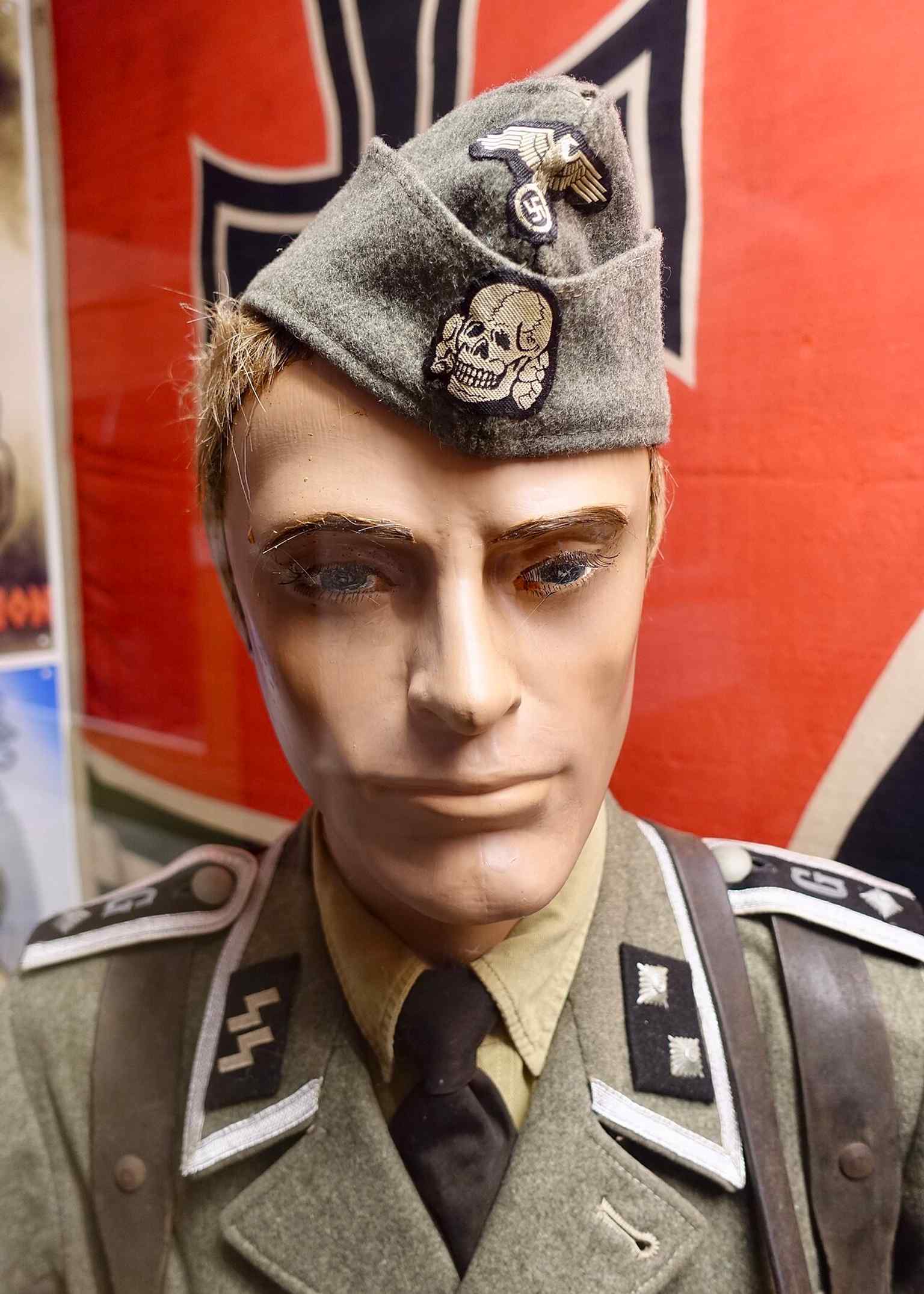 A Waffen-SS field uniform with SS runes and Totenkopf insignia, reflecting the branch’s military role on the Eastern Front.